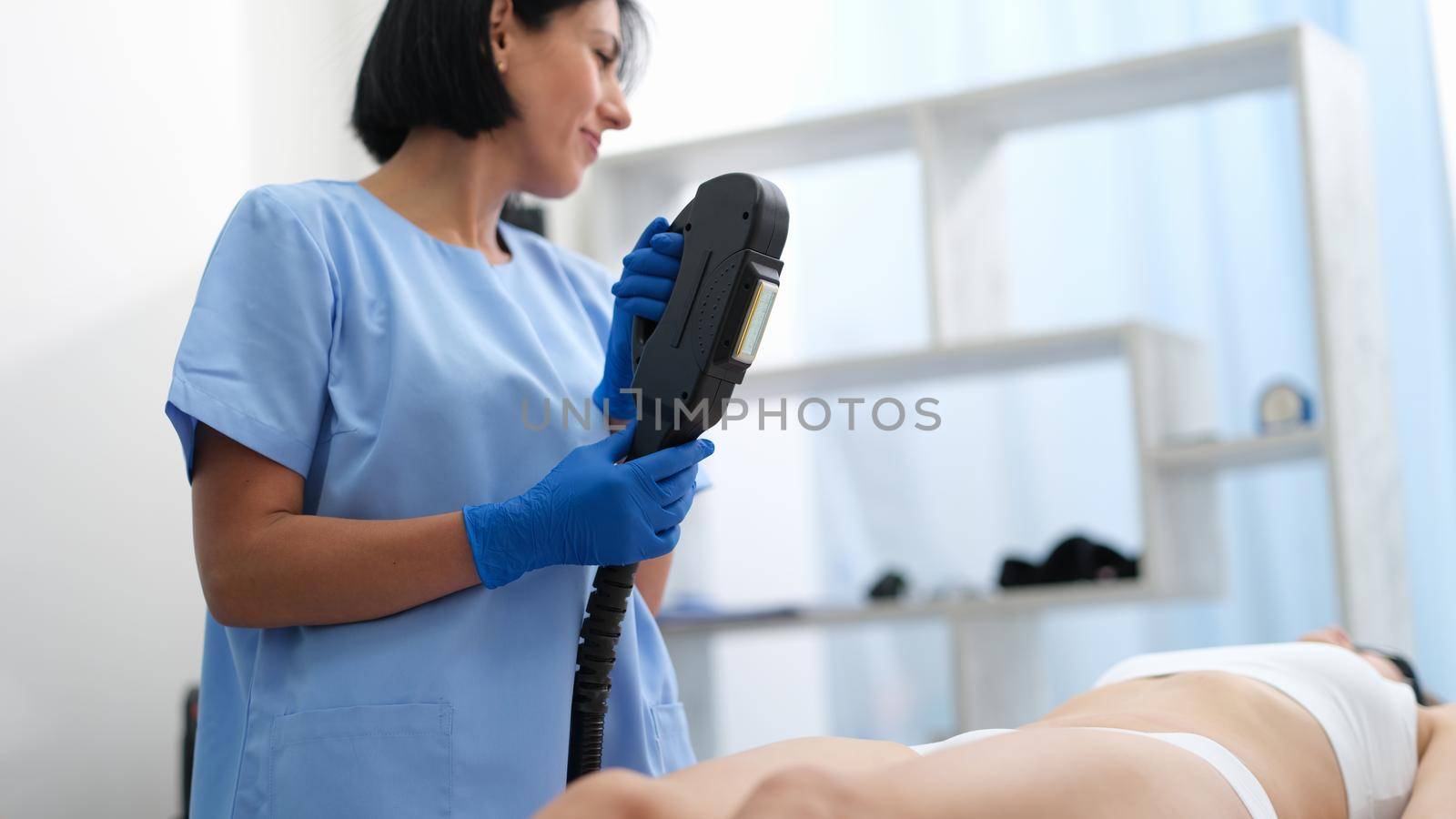 Woman beautician sets up laser hair removal by kuprevich