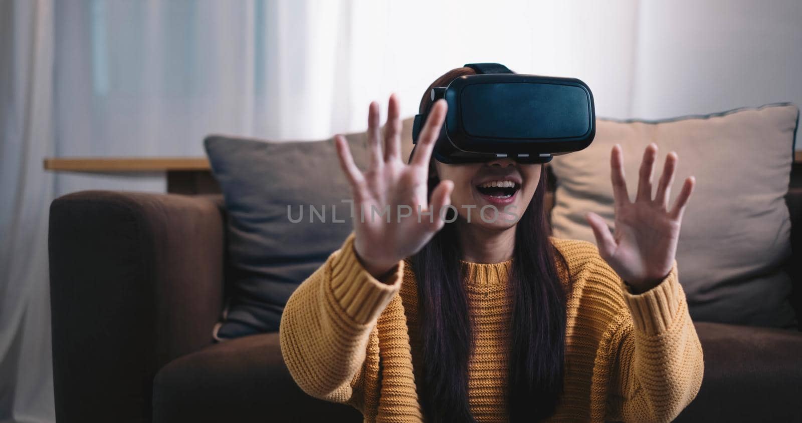 Asian woman play VR game for entertain at home, asian woman joyful in house on holiday. Happy woman playing metaverse VR technology concept..