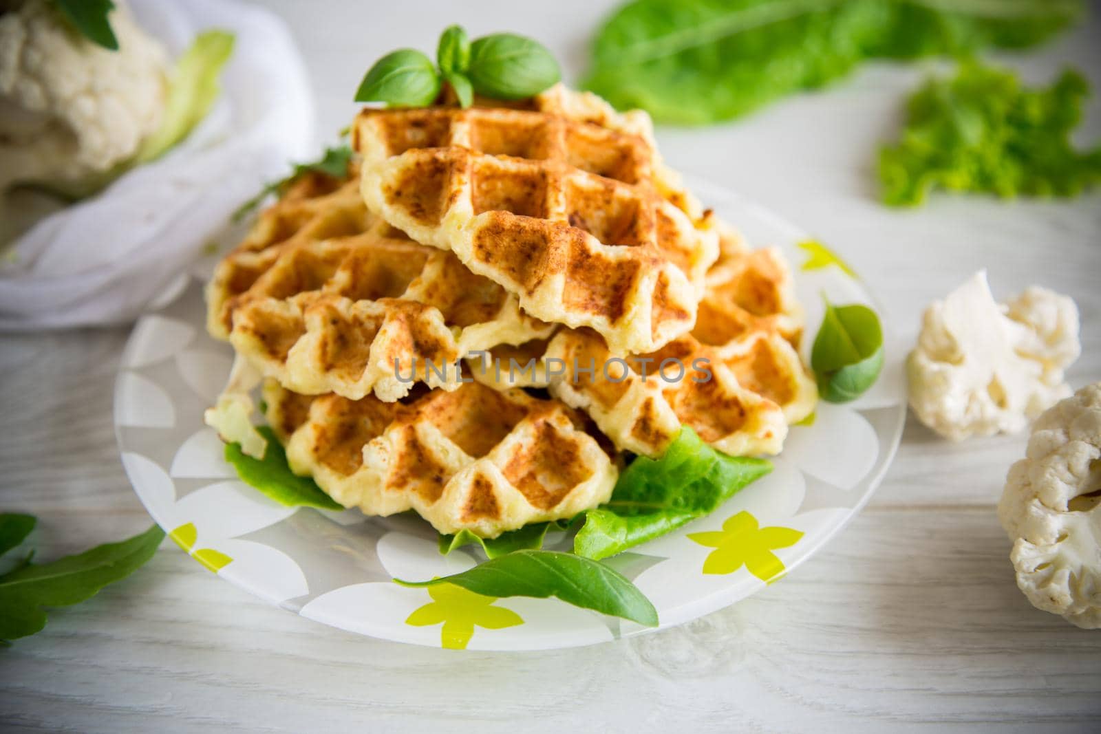 vegetable waffles cooked with cauliflower in a plate on a wooden table.