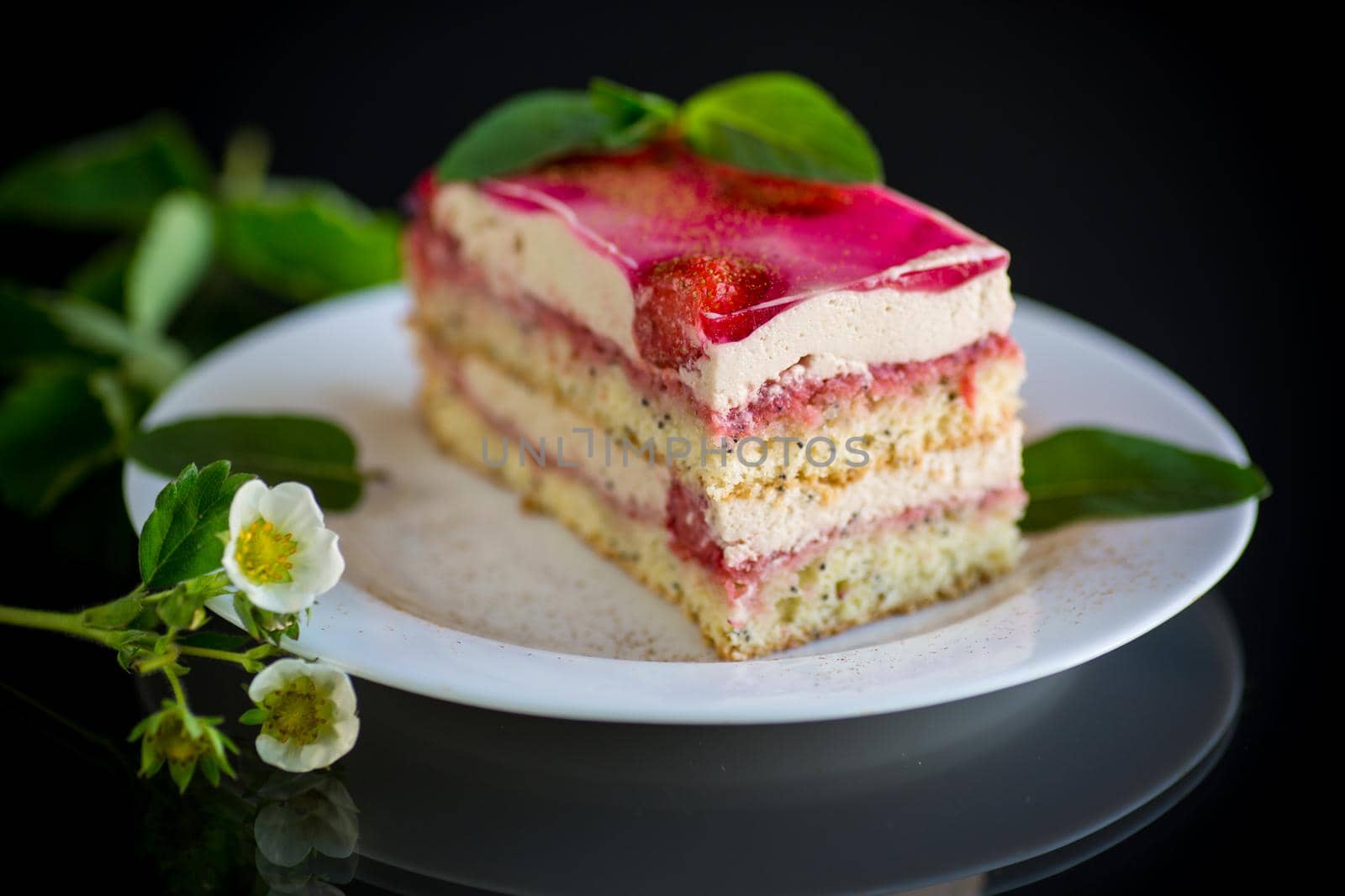 strawberry poppy cake with cream in a plate isolated on black background