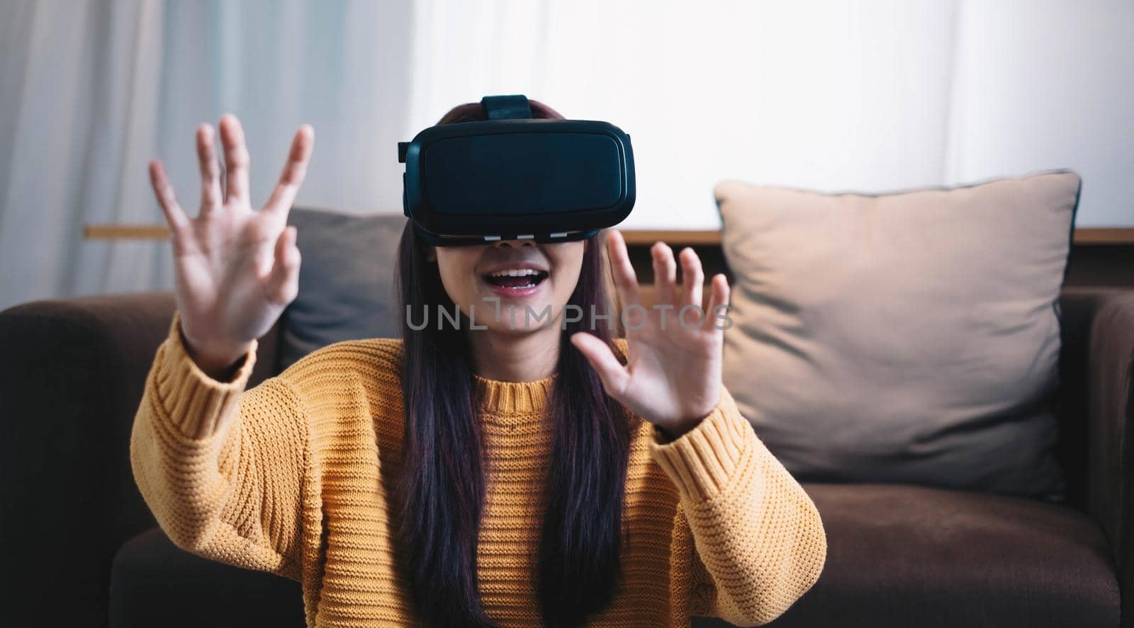 Asian woman play VR game for entertain at home, asian woman joyful in house on holiday. Happy woman playing metaverse VR technology concept. by wichayada