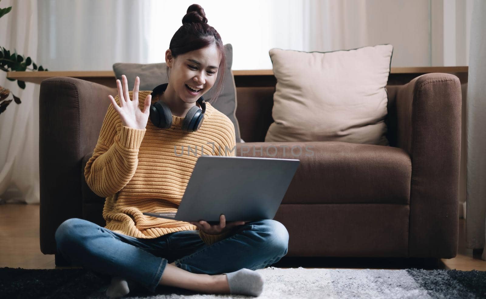 Shot of pretty young woman using her laptop while sitting on the floor at home. by wichayada