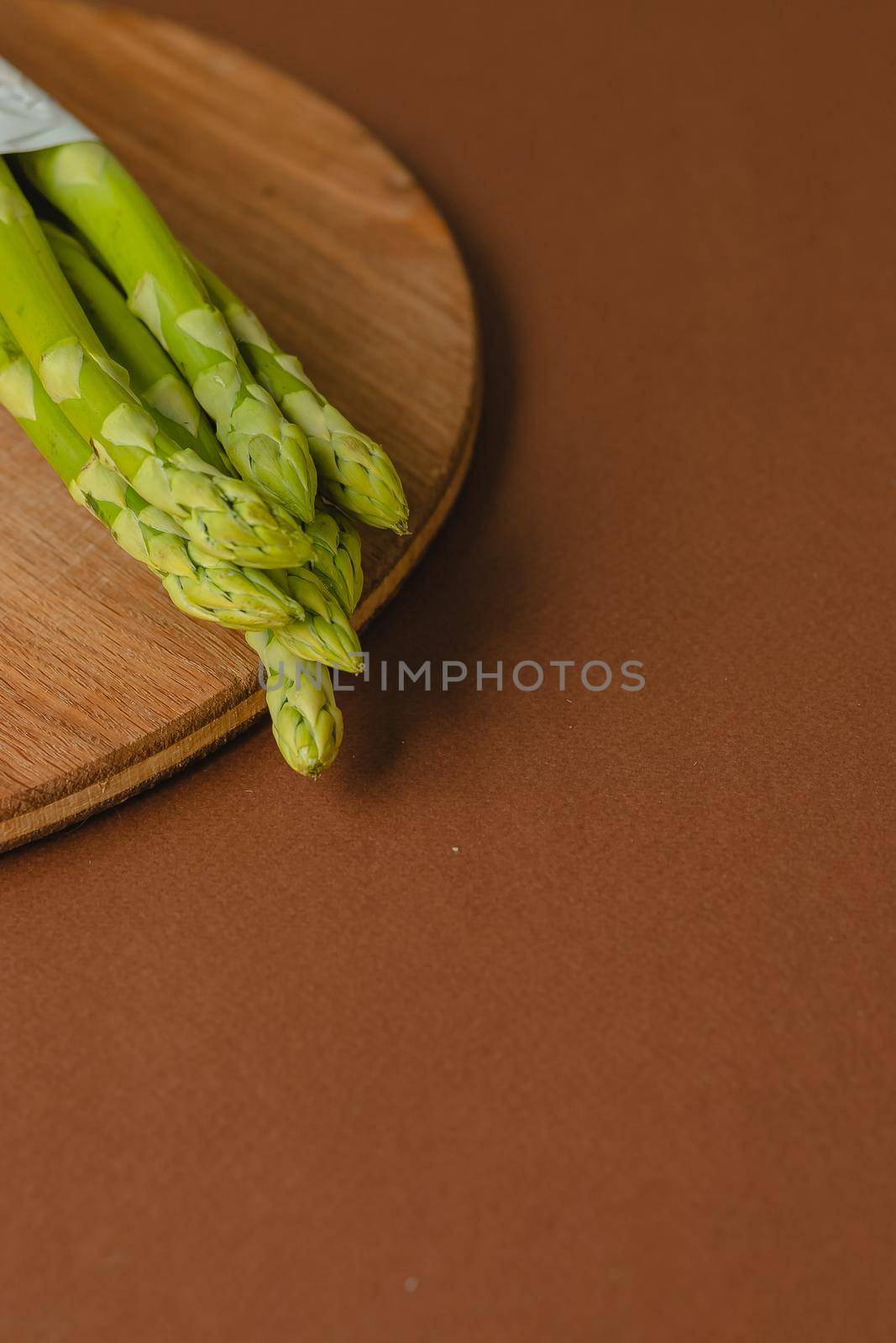 branches of fresh green asparagus on a wooden background, top view