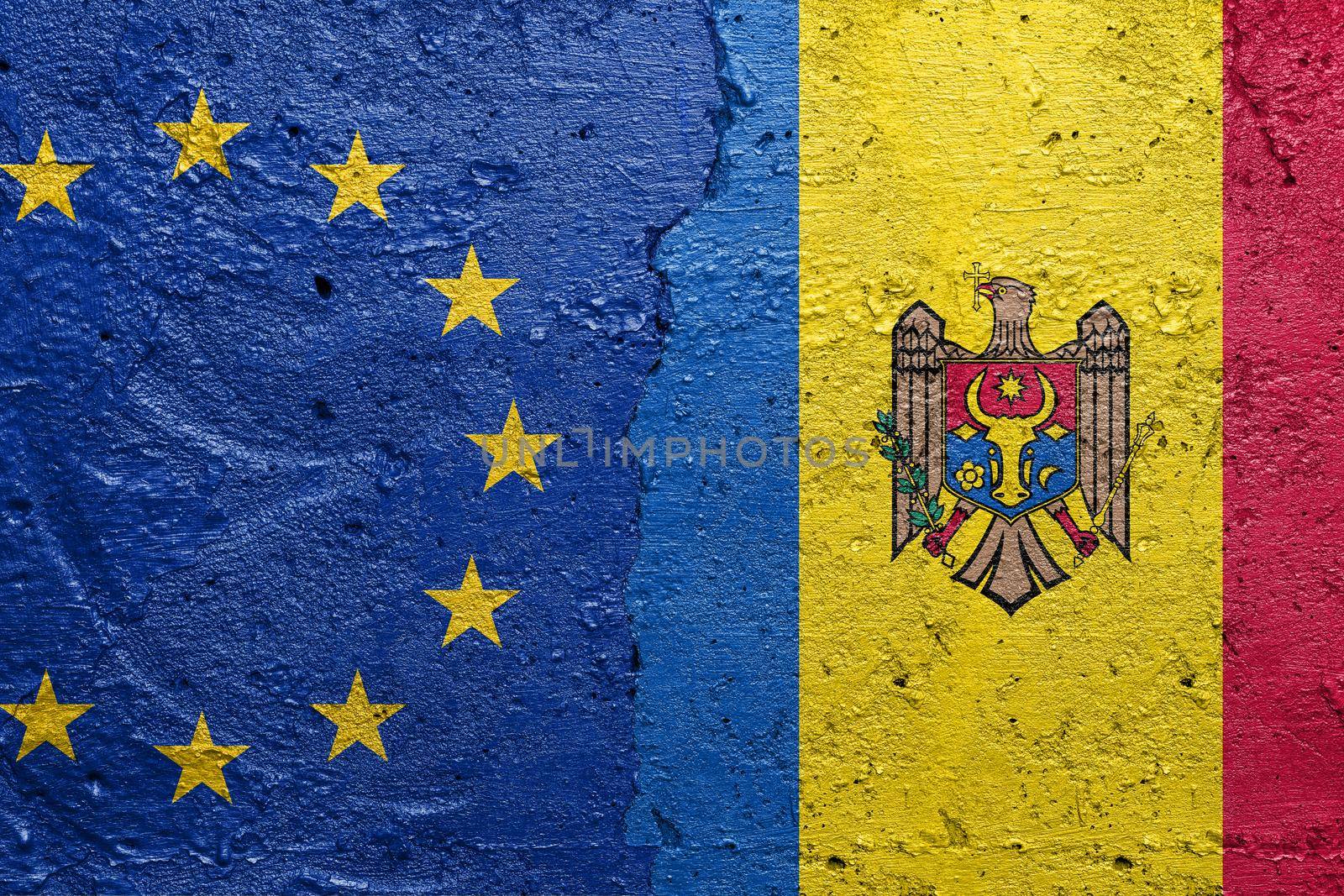 European Union and Moldova - Cracked concrete wall painted with a EU flag on the left and a Moldovan flag on the right stock photo by adamr