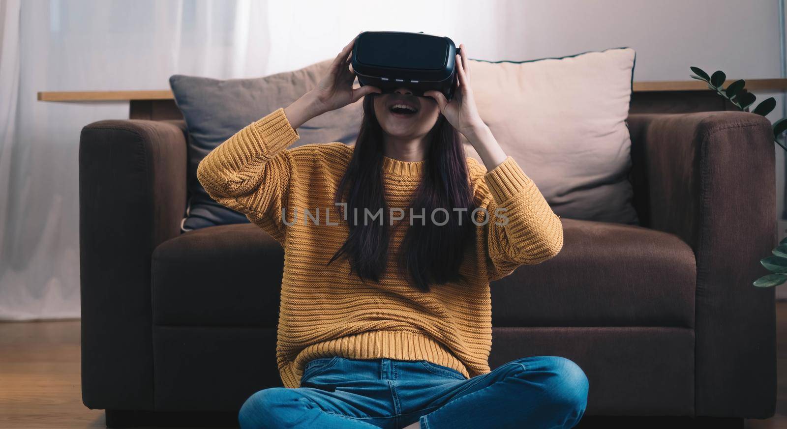 Asian woman play VR game for entertain at home, asian woman joyful in house on holiday. Happy woman playing metaverse VR technology concept..