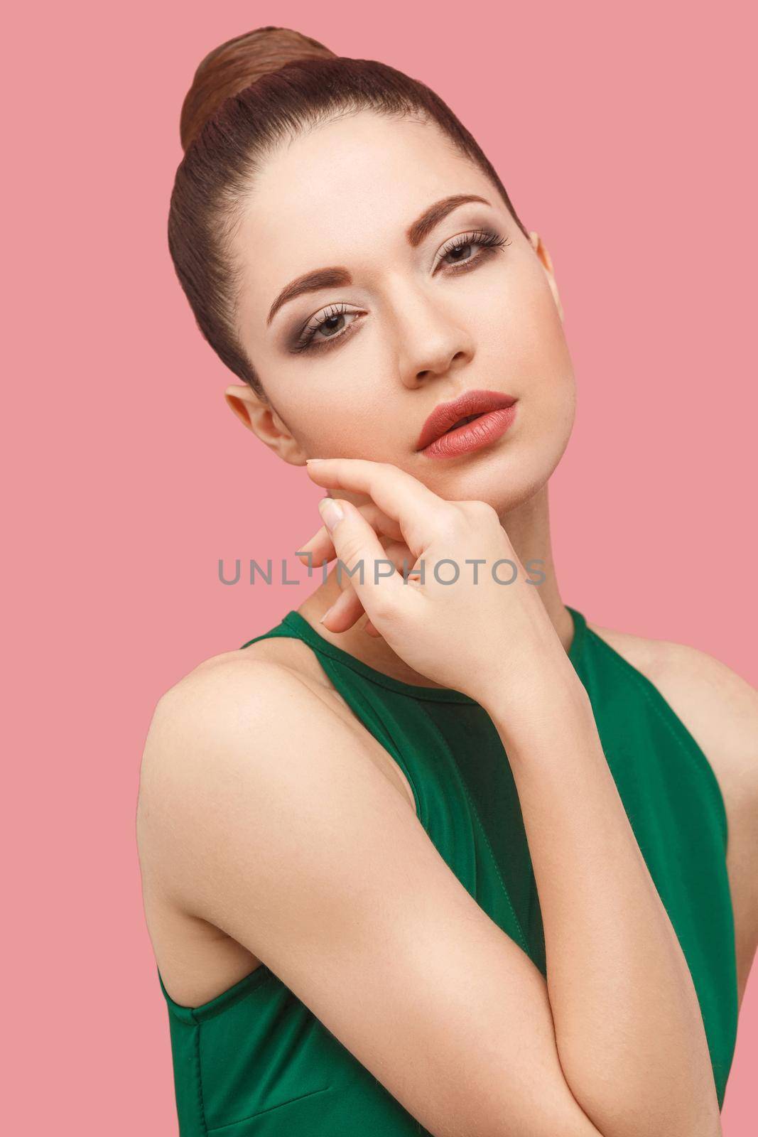 Beauty concept of young beautiful female model in green dress on pink background. by Khosro1