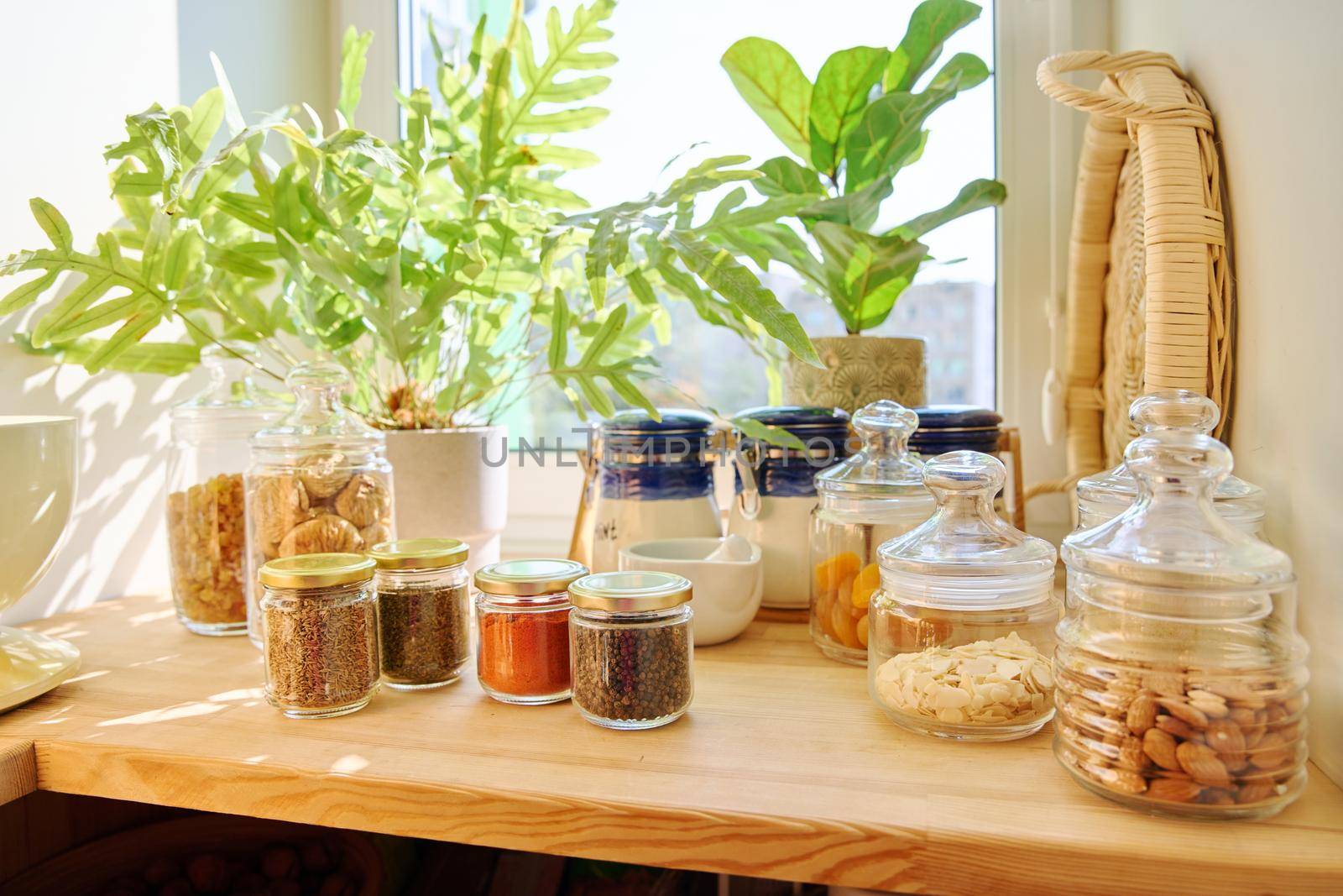 Storage of food in the kitchen in pantry. Glass jars with different spices, nuts, dry fruits. Cooking at home, stocking food