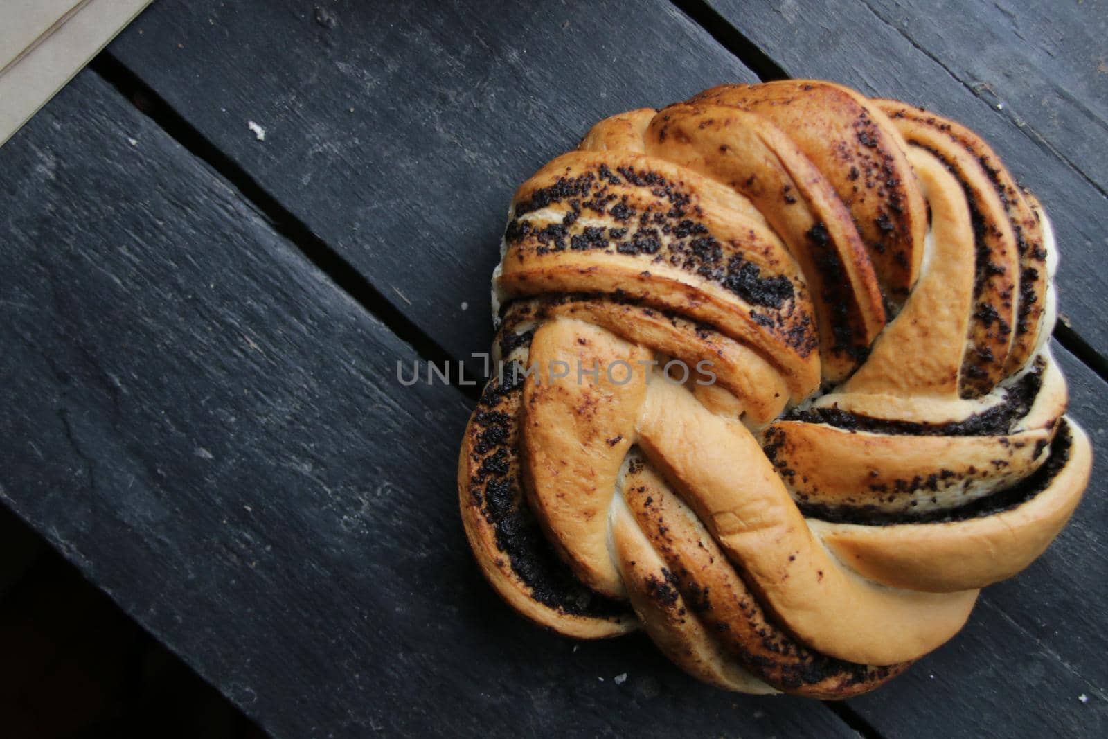 Sweet roll with poppy seeds on a vintage table