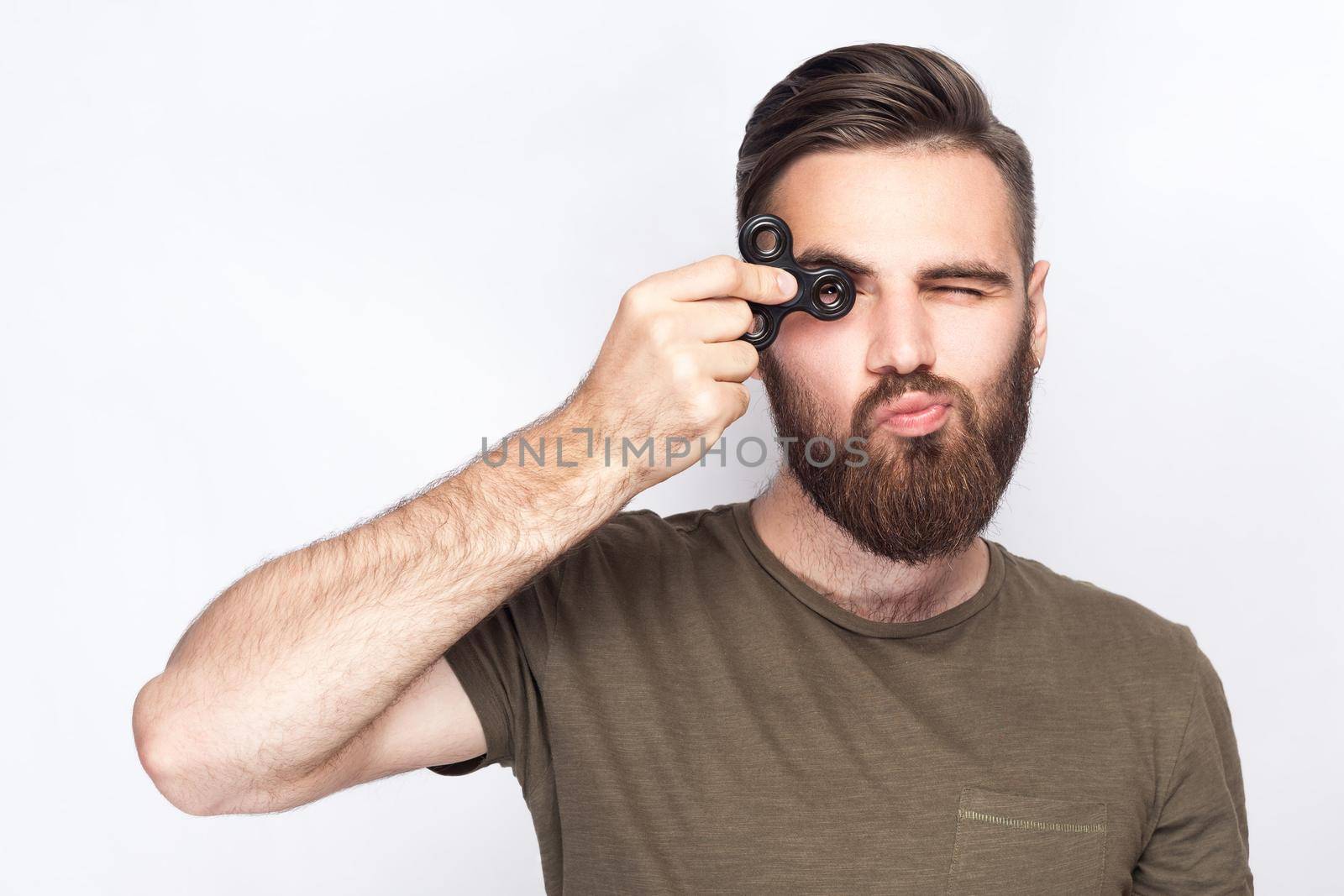 Young man holding and playing with fidget spinner. studio shot on white background. .