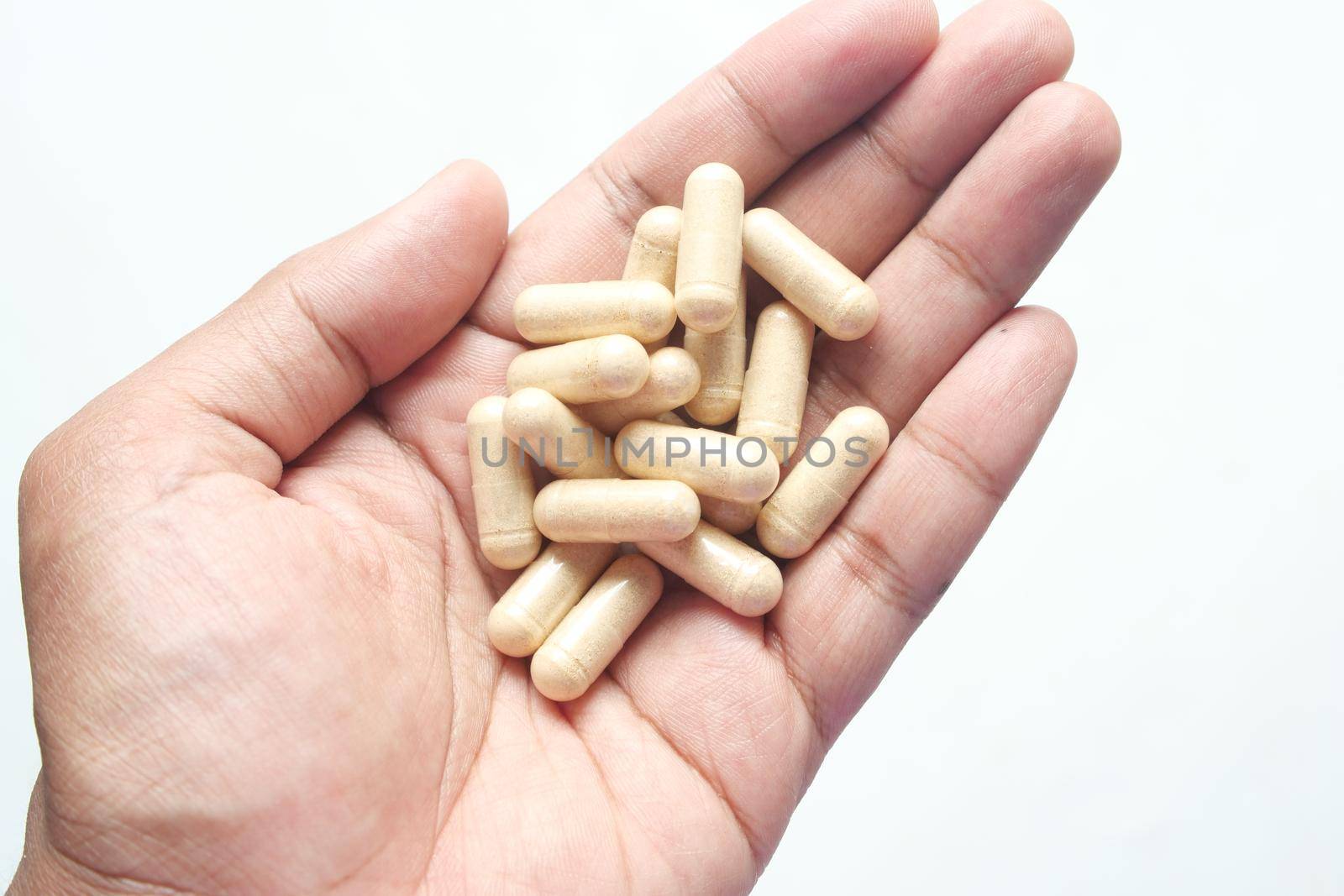 top view of herbal medicine capsule dropping on white ,