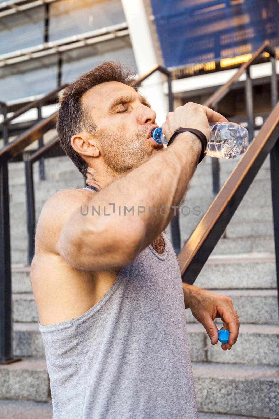 Thirsty sportsman take a rest and drinking water after running. by Khosro1