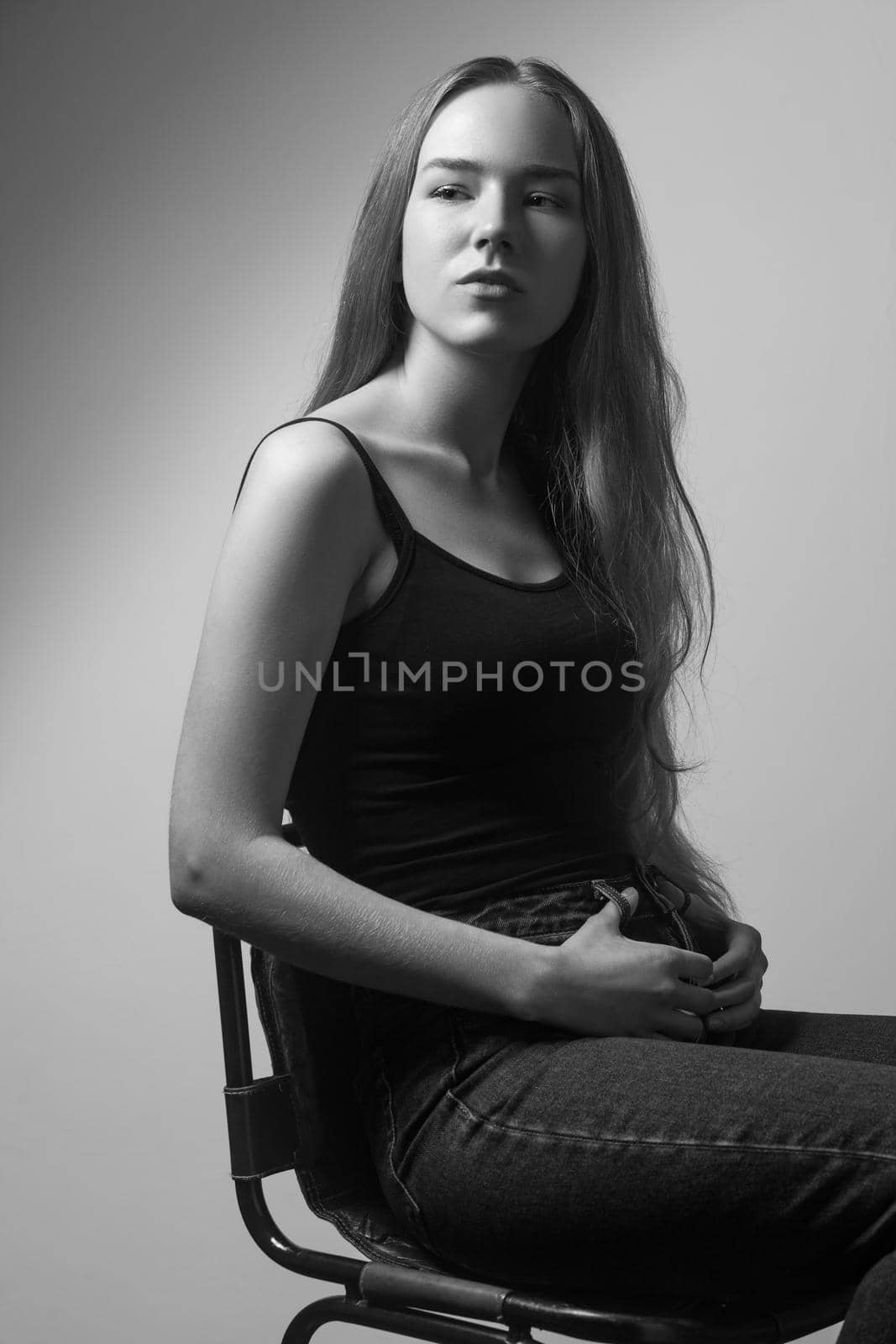 Portrait of proud woman, looking looking at camera. Studio shot, isolated on gray background