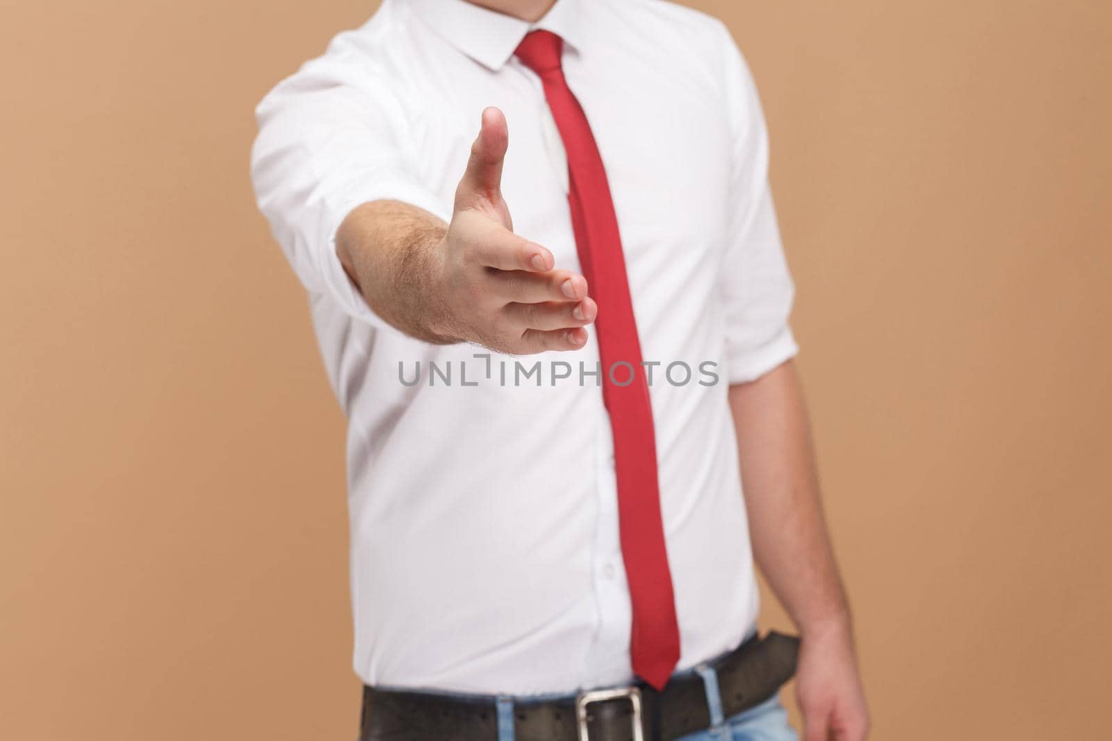 man shows handshake sign and welcome new job. Business people concept, good and bad emotion and feelings. Studio shot, isolated on light brown background