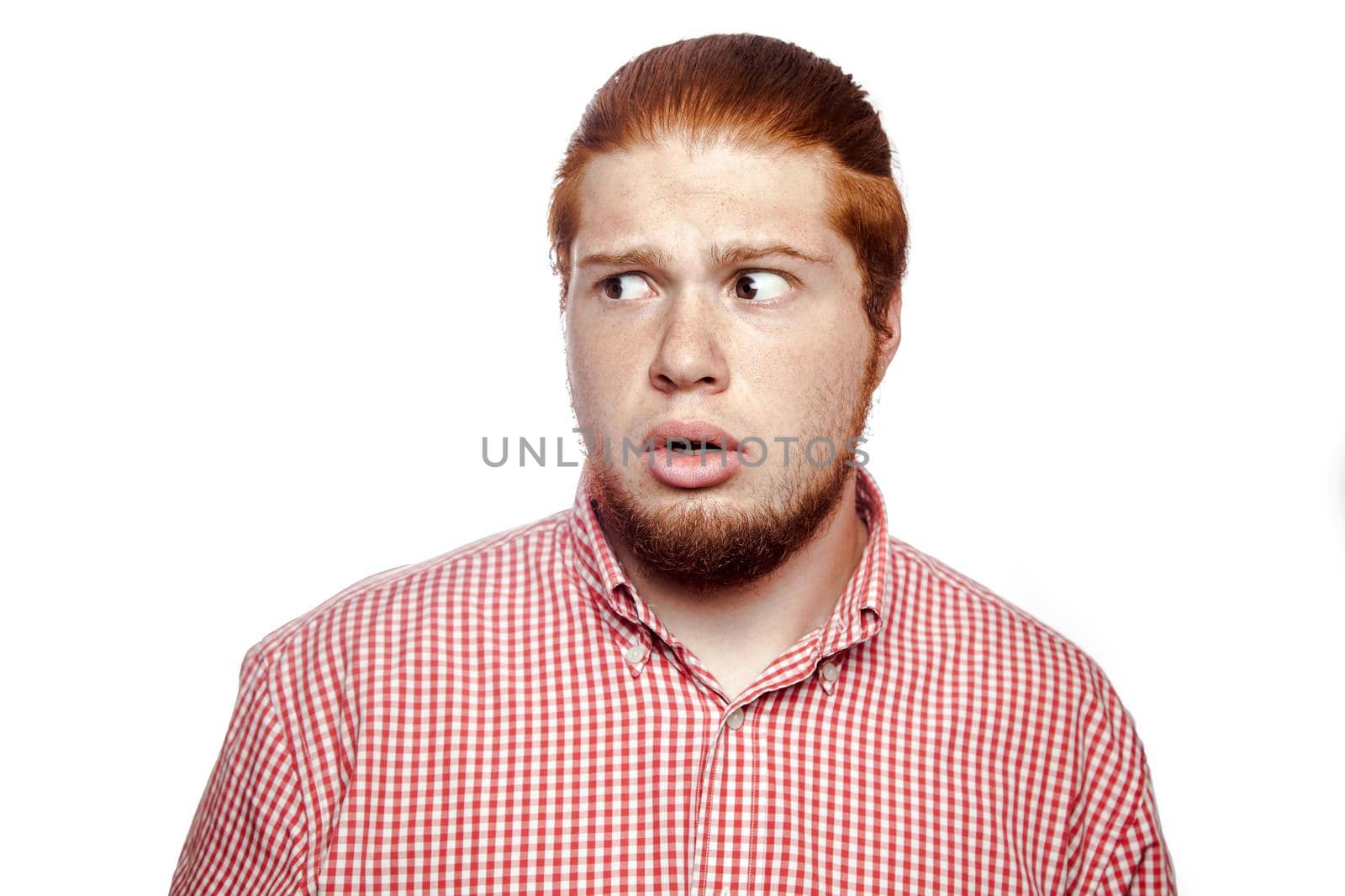 shock scared bearded readhead businessman with red shirt and freckles looking at camera. studio shot isolated on white.