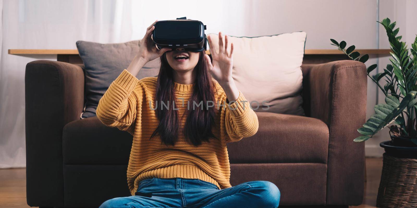 Asian woman play VR game for entertain at home, asian woman joyful in house on holiday. Happy woman playing metaverse VR technology concept..