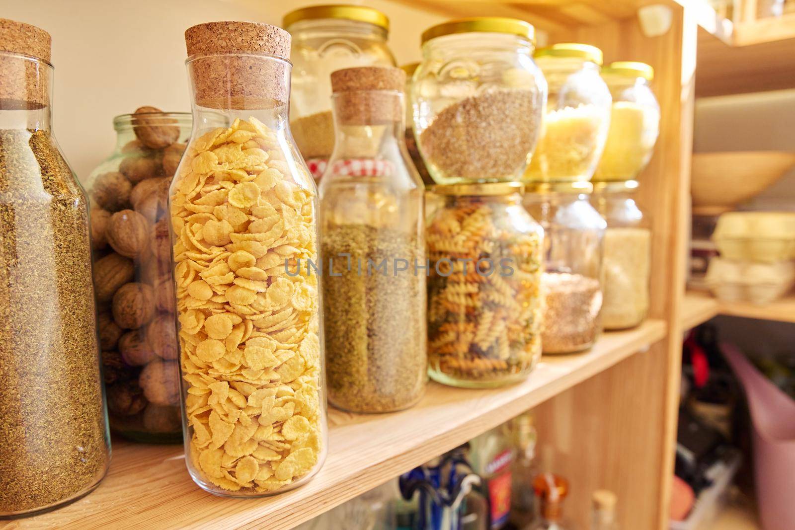 Storage of food in the kitchen in the pantry. Cereals, spices, pasta, nuts, flour in jars and containers, kitchen utensils. Cooking at home, stocking food, household