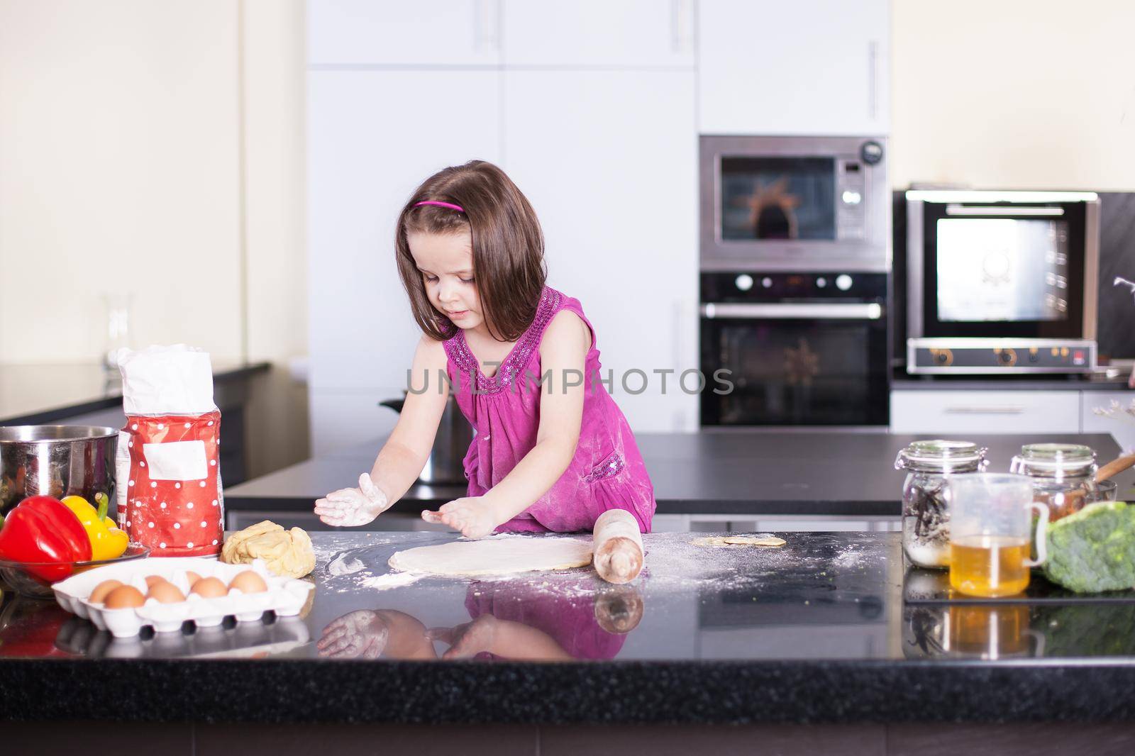 Girl cooks food in the kitchen at home. Little cook.