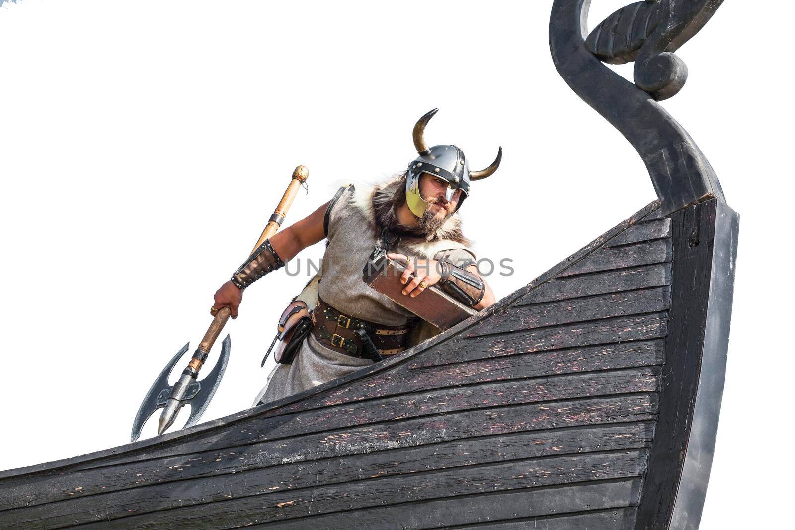 Strong Viking on his ship. Angry man with historical weapon and helmet on ship looking. and ready to attack.