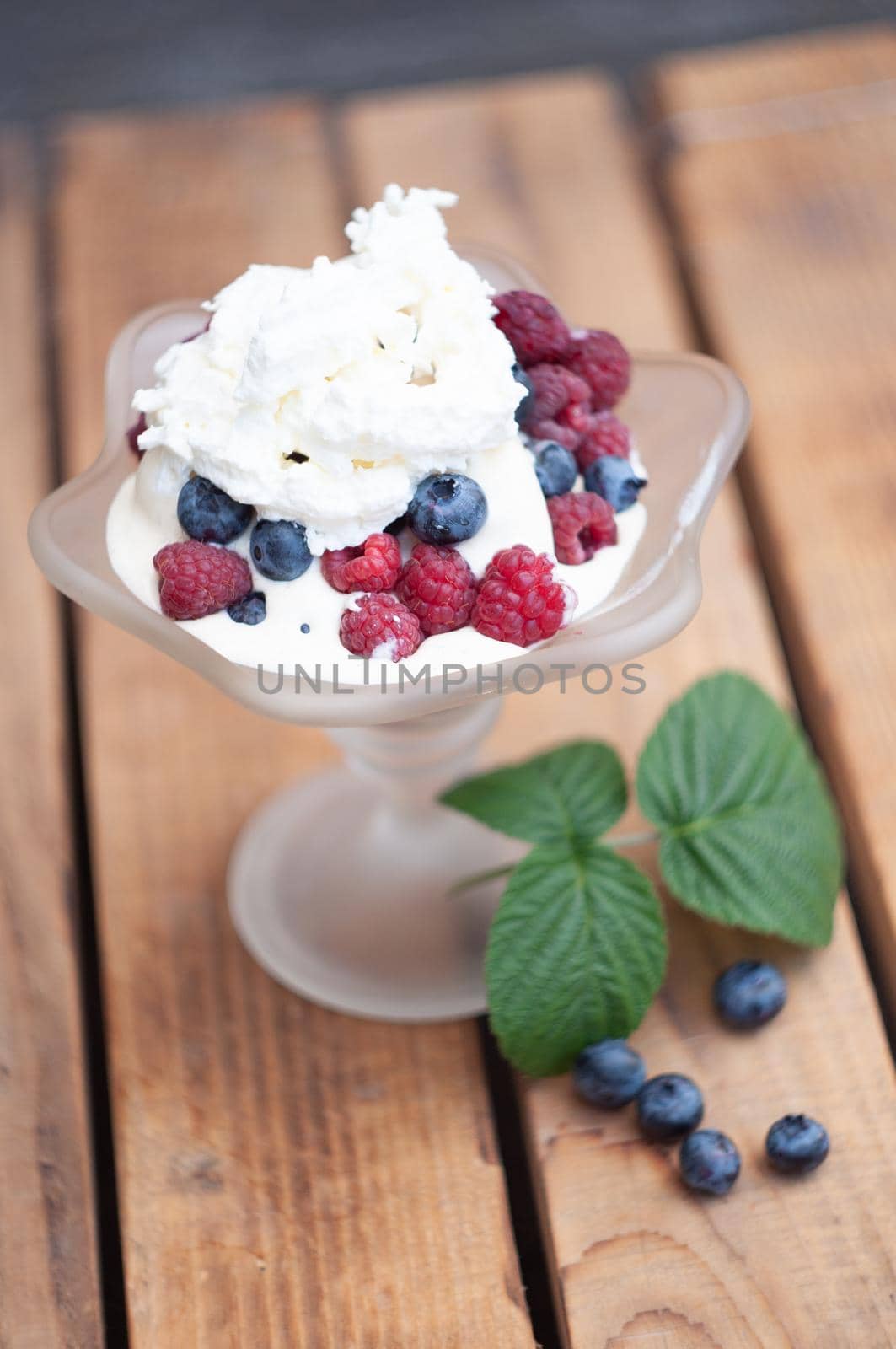 Vanilla ice cream with fresh berries and whipped cream, summer dessert with natural vitamins. High quality photo