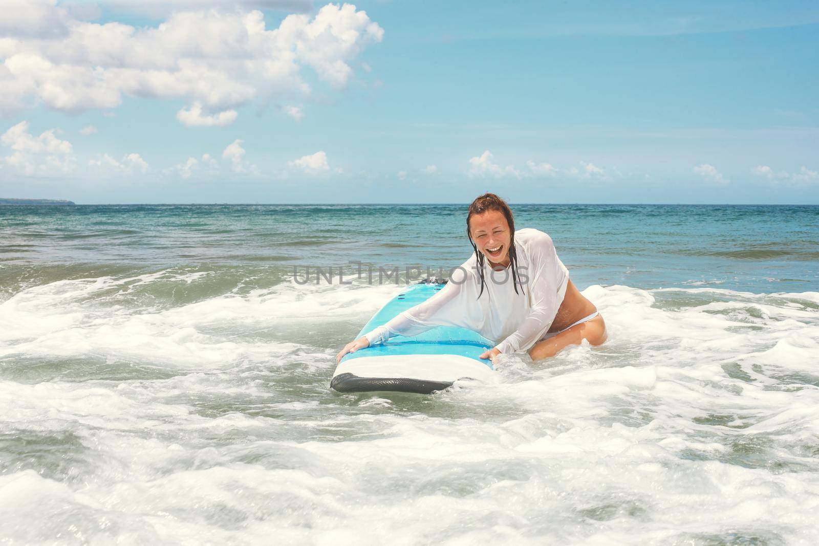 Girl on the waves in the ocean with her Surfboard. Stock image