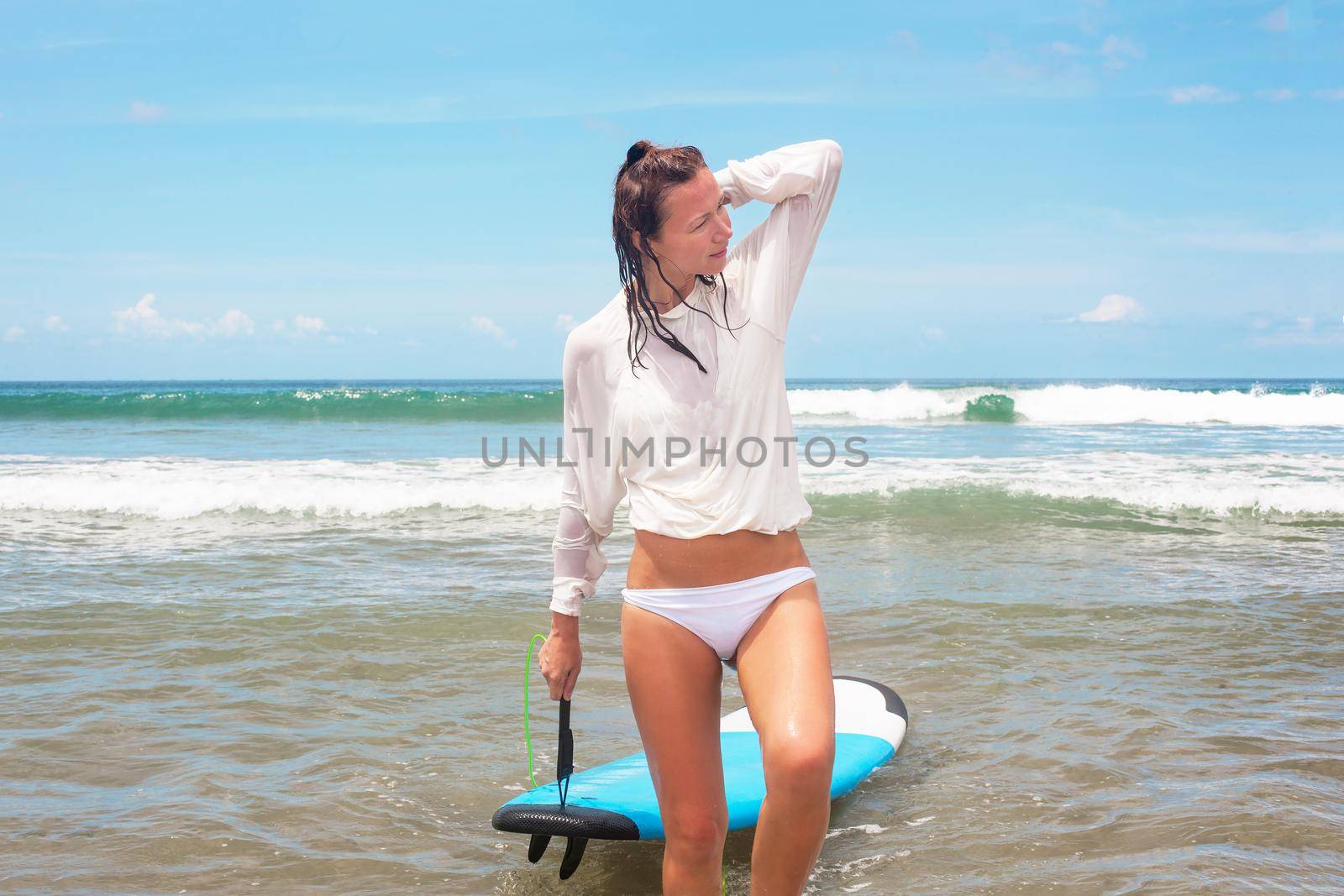 Girl on the waves in the ocean with her Surfboard. Stock image