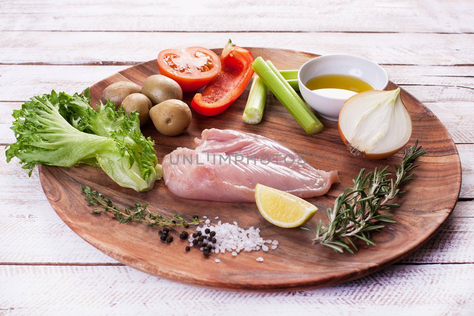 Ingredients for vegetable salad with chicken breast on a wooden plate. Stock image.