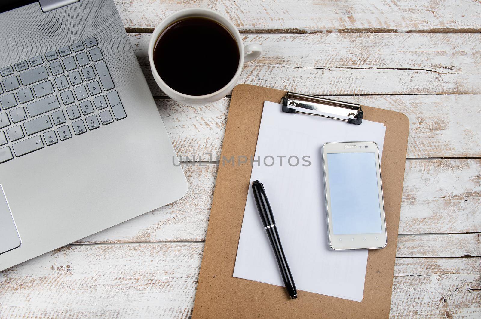 Cup of coffee and laptop on wooden table. Stock image.
