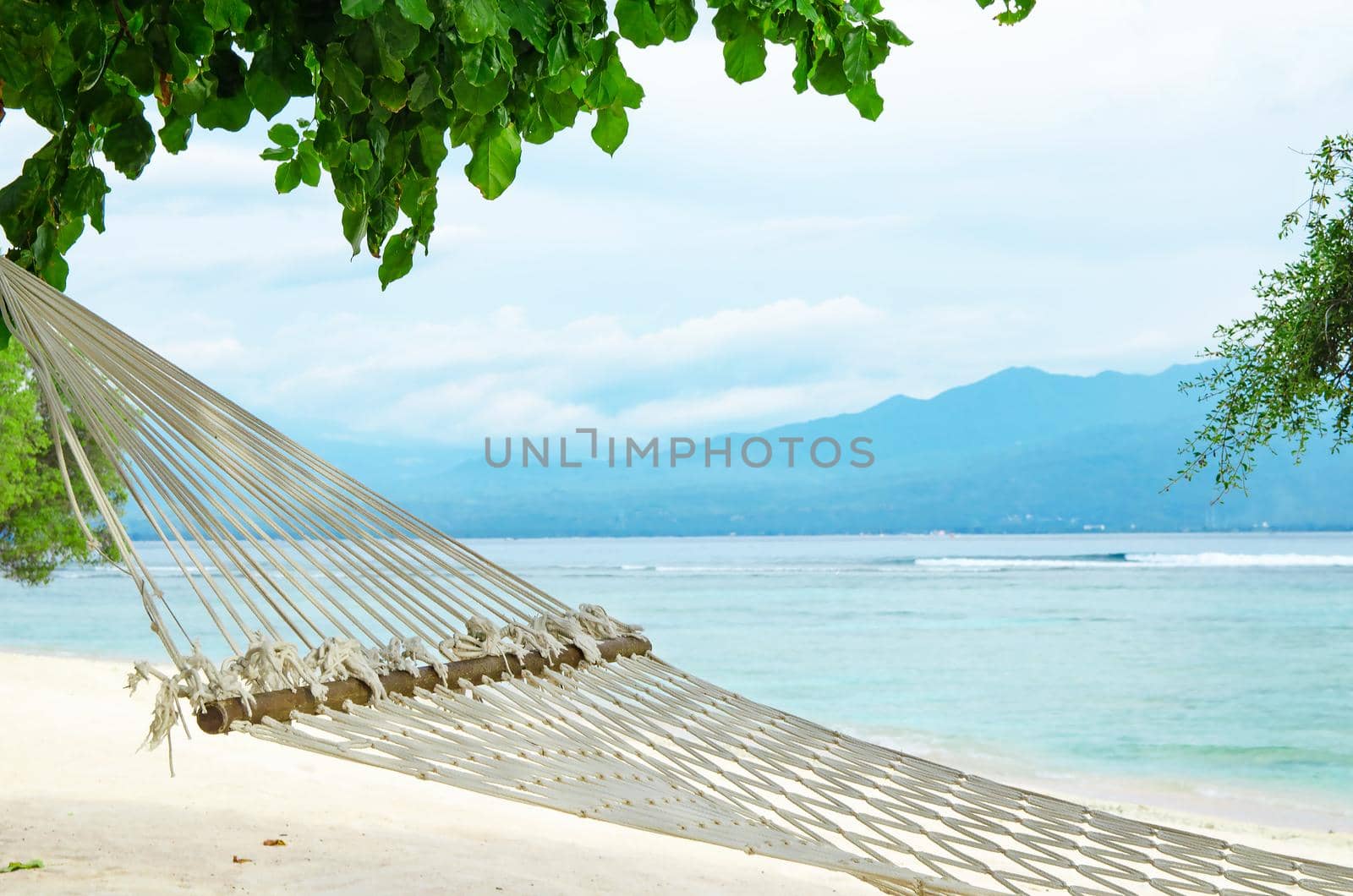 Hammock hanging in the trees on an exotic beach in Bali, Indonesia. Stock image.