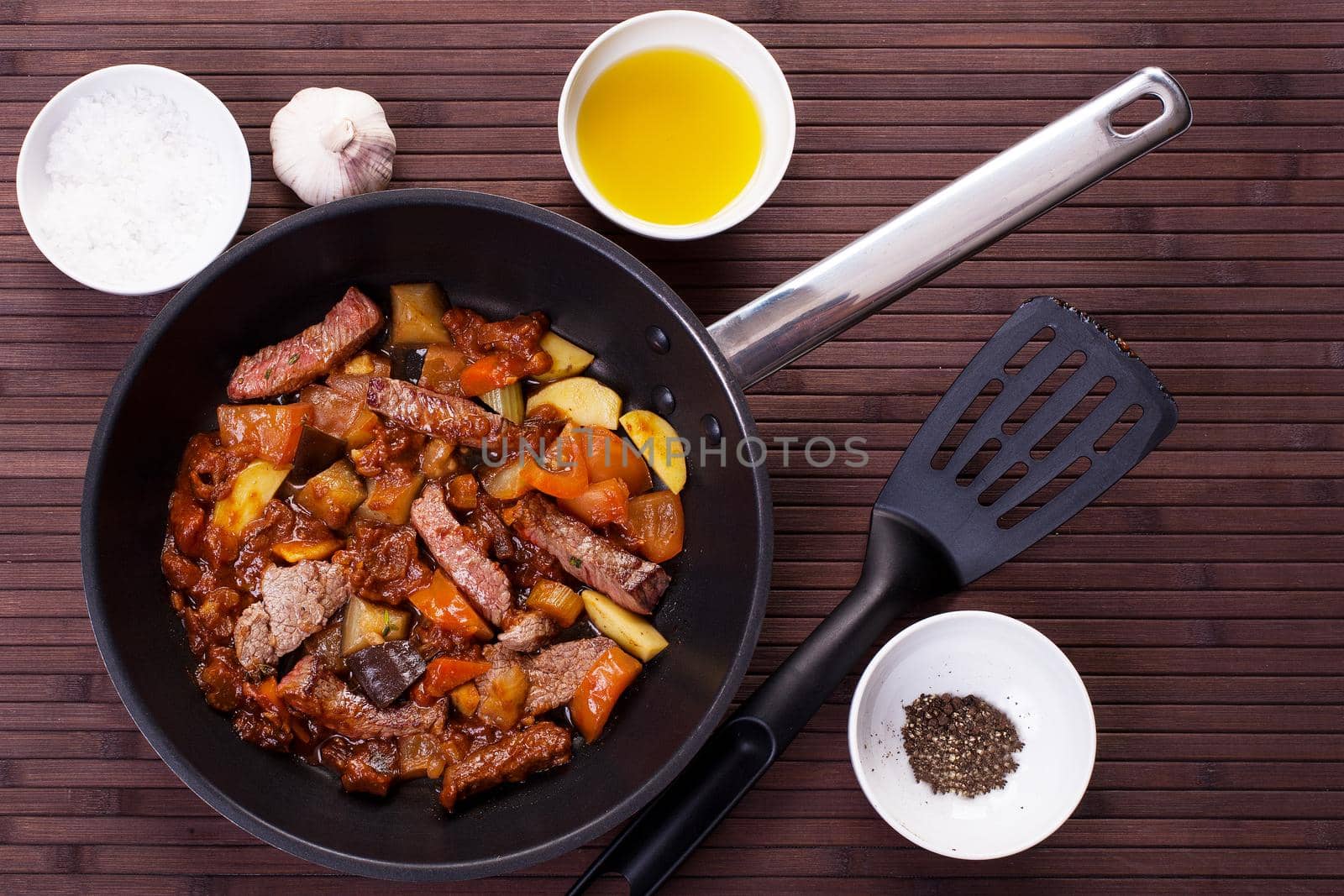 Braised veal with eggplant and other vegetables in a pan. Stock image.