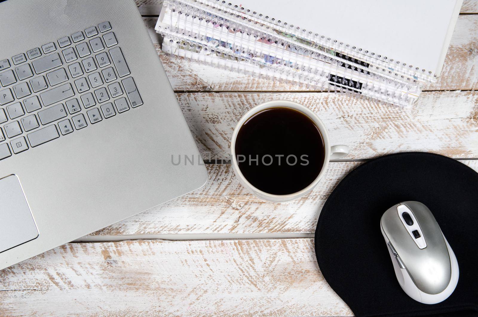 Cup of coffee and laptop on wooden table. Stock image.