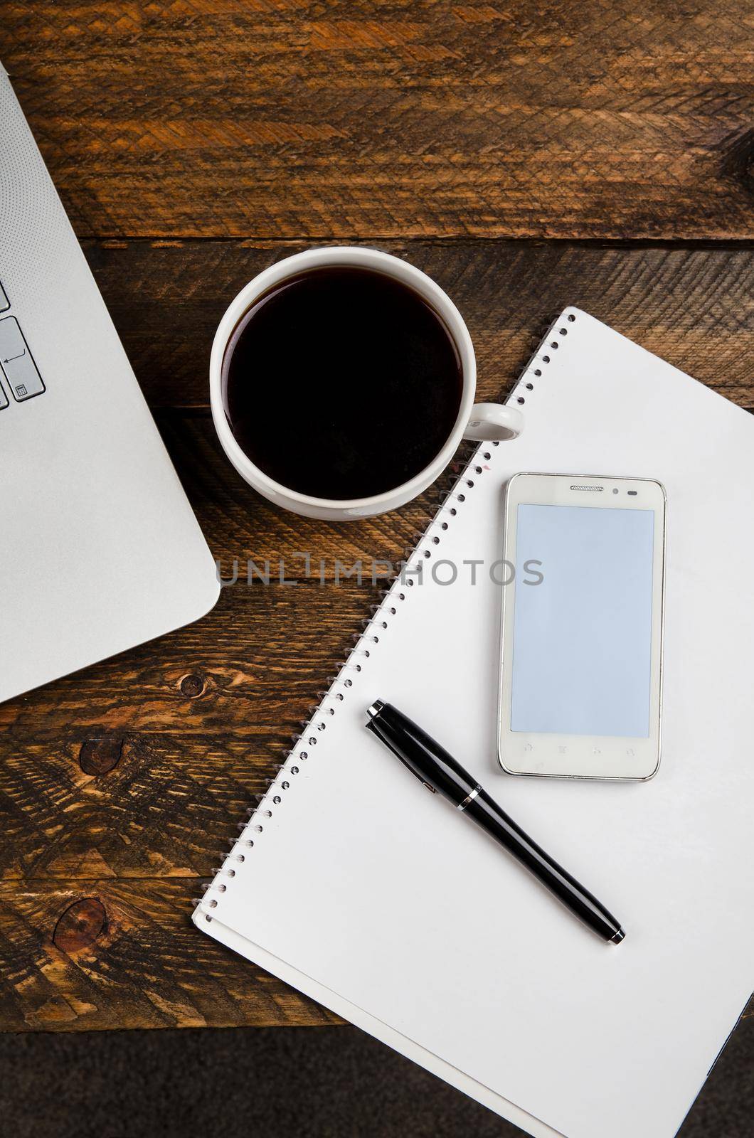 Cup of coffee and laptop on wooden table. Stock image.