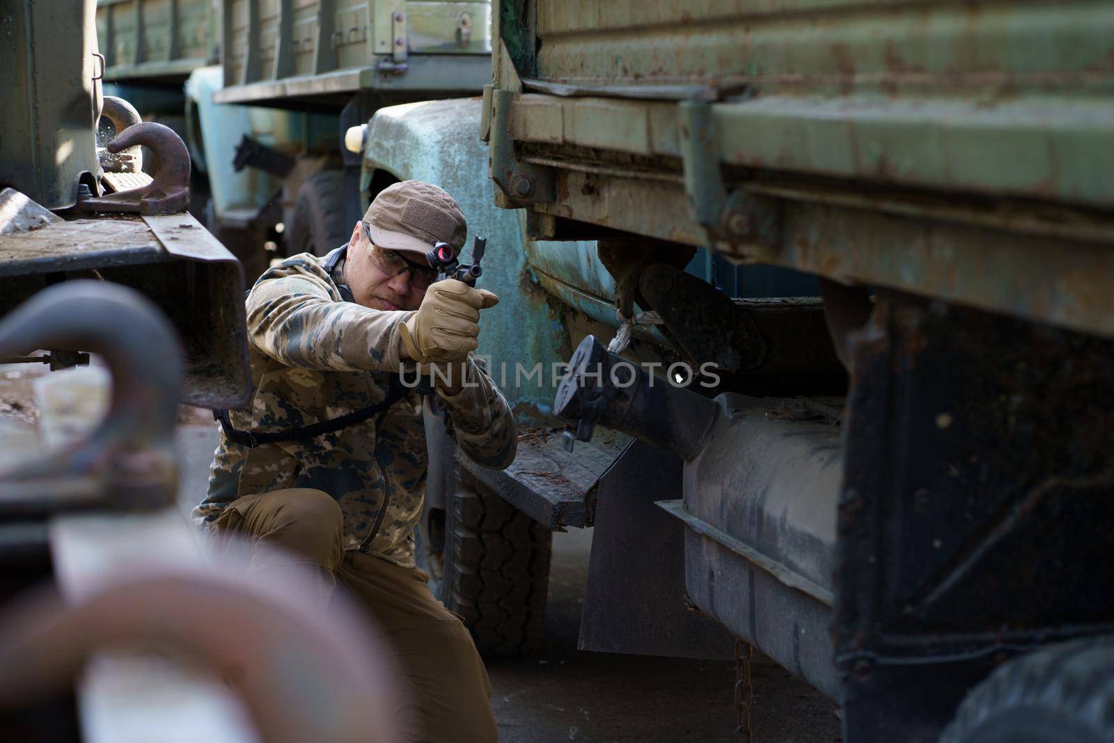 Defensive tactics shooter course, man with a gun in military uniform. Tactical training course young man. Outdoor shooting range. Private military contractor at tactical training course.