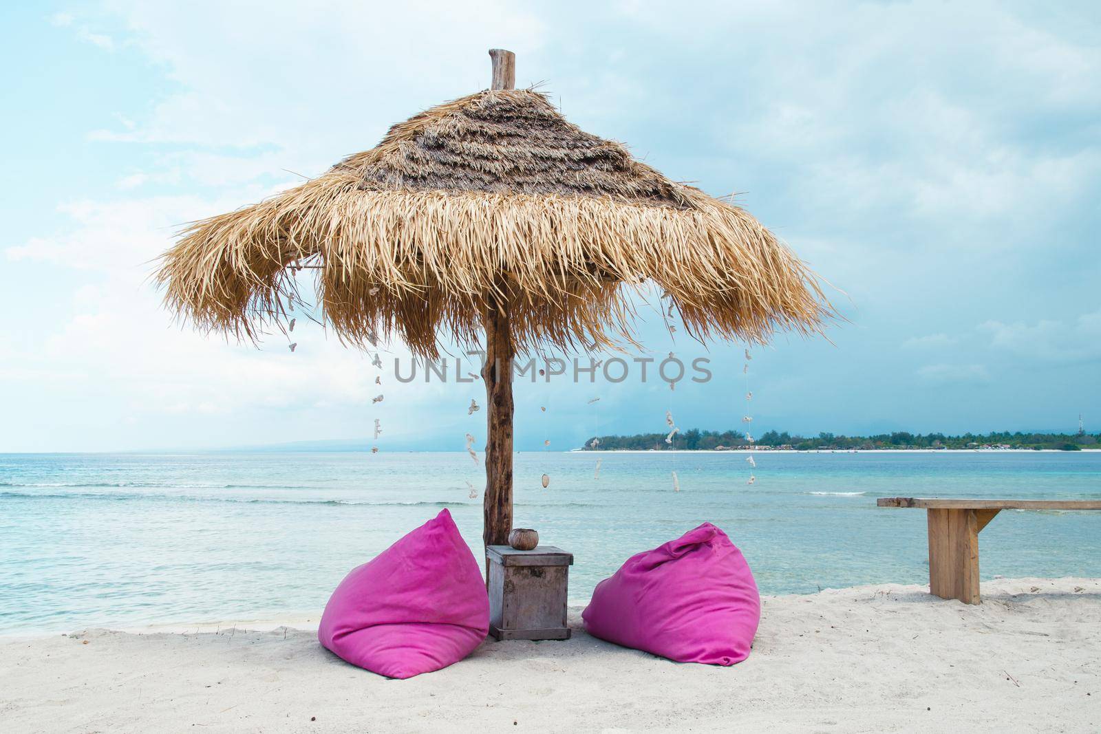 Beach umbrella and deck chairs on the bright tropical island of Bali. Stock image.
