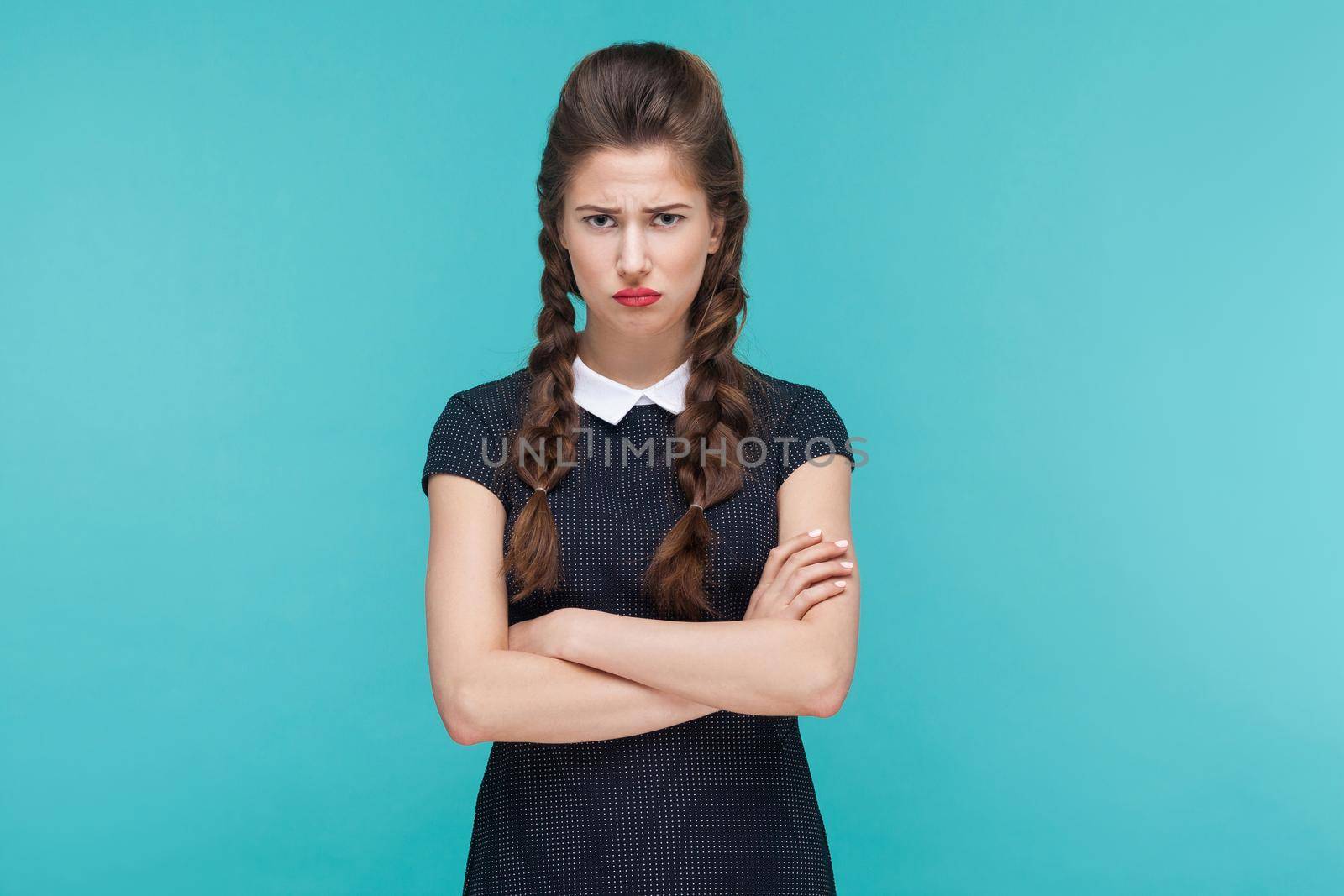 Unhappy businesswoman crossed hands and sadness. Studio shot, blue background