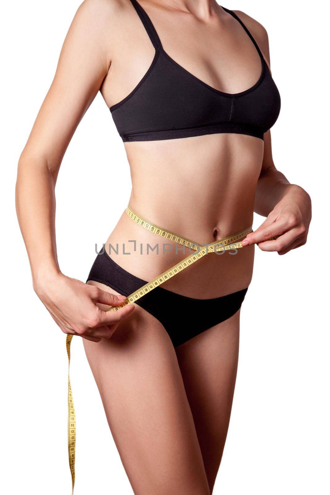 Slim fit happy young woman with measure tape measuring her waist with black underwear, isolated on white background. studio shot.