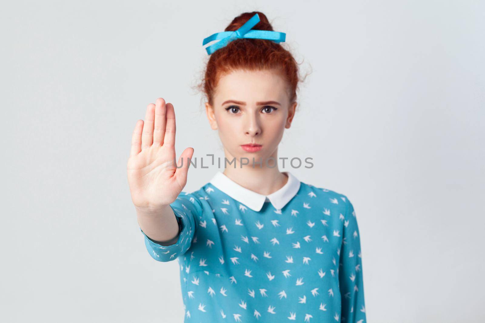 Stop! begative emotions, feelings, body language. Isolated studio shot on gray background. Young annoyed redhead girl with bad attitude making stop gesture