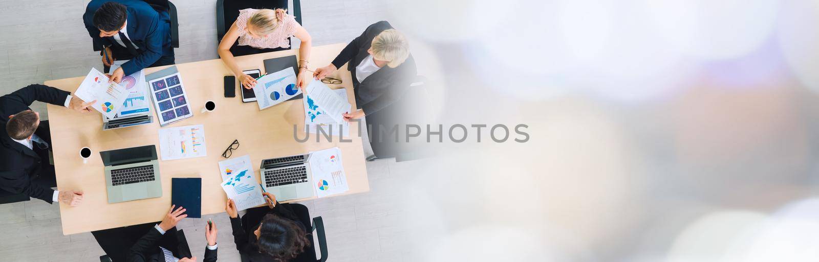 Business people group meeting shot from top widen view in office . Profession businesswomen, businessmen and office workers working in team conference with project planning document on meeting table .