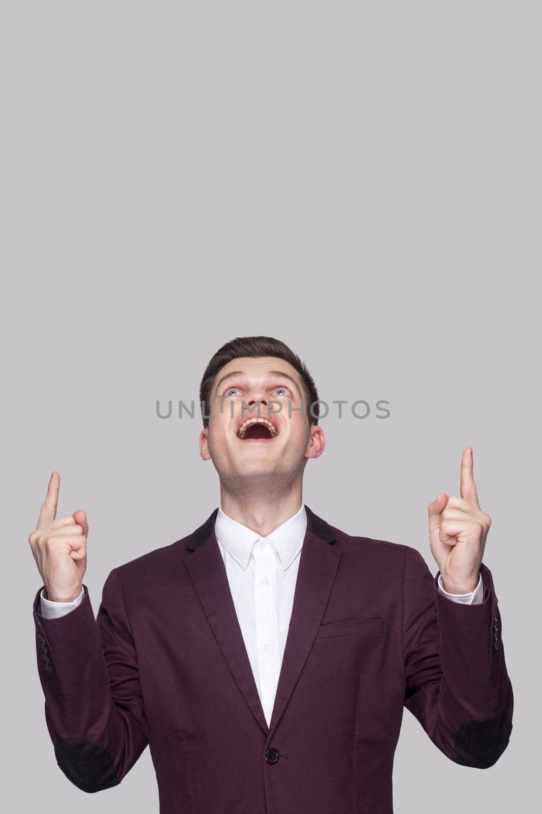 Emotional young man in suit on gray background by Khosro1