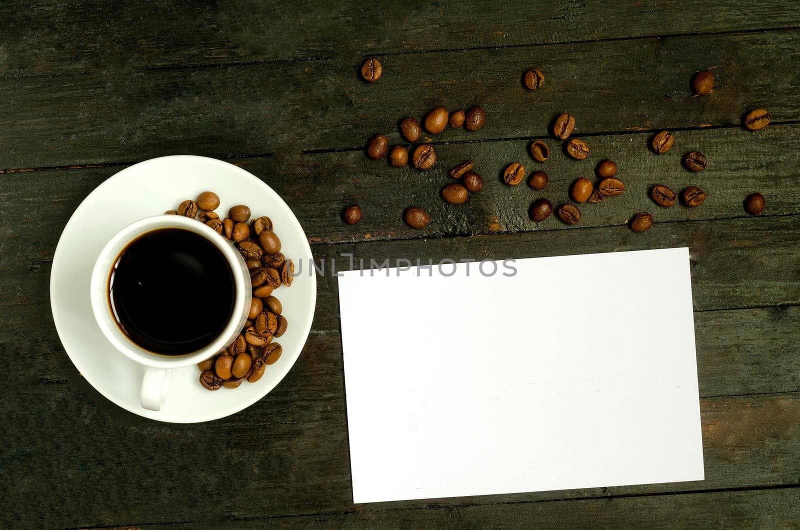 a cup of coffee with coffee beans on wooden table.Flatlay, mock up. by andre_dechapelle