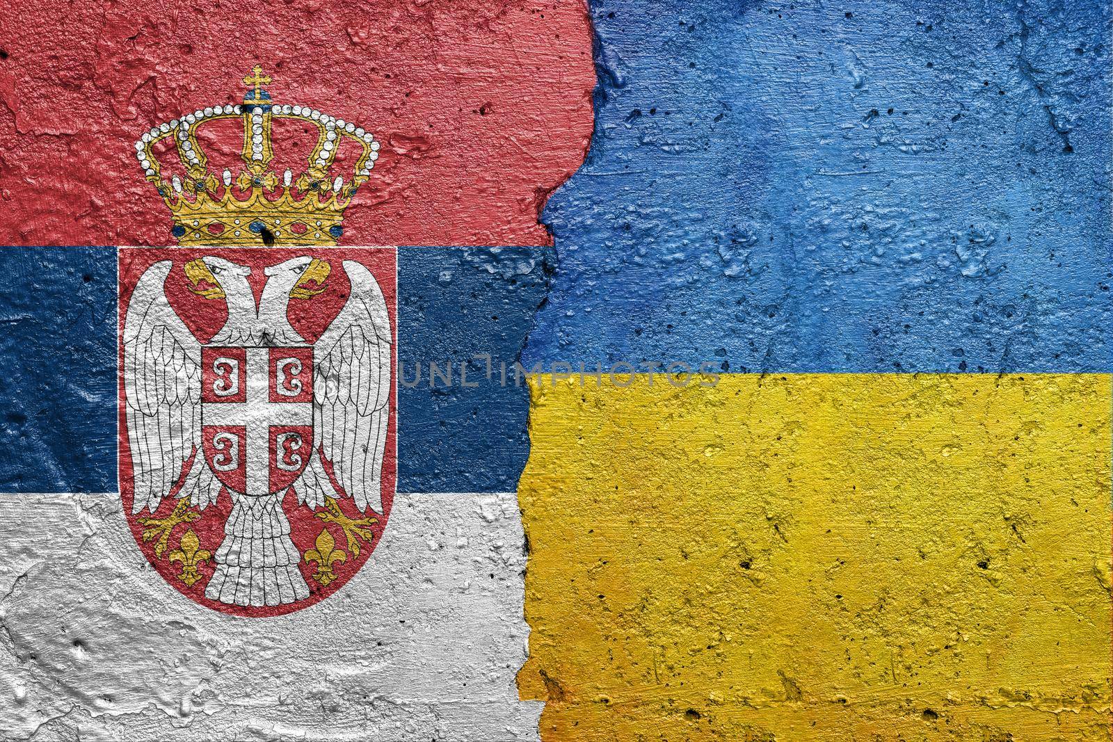 Serbia and Ukraine flags  - Cracked concrete wall painted with a Serbian flag on the left and a Ukrainian flag on the right