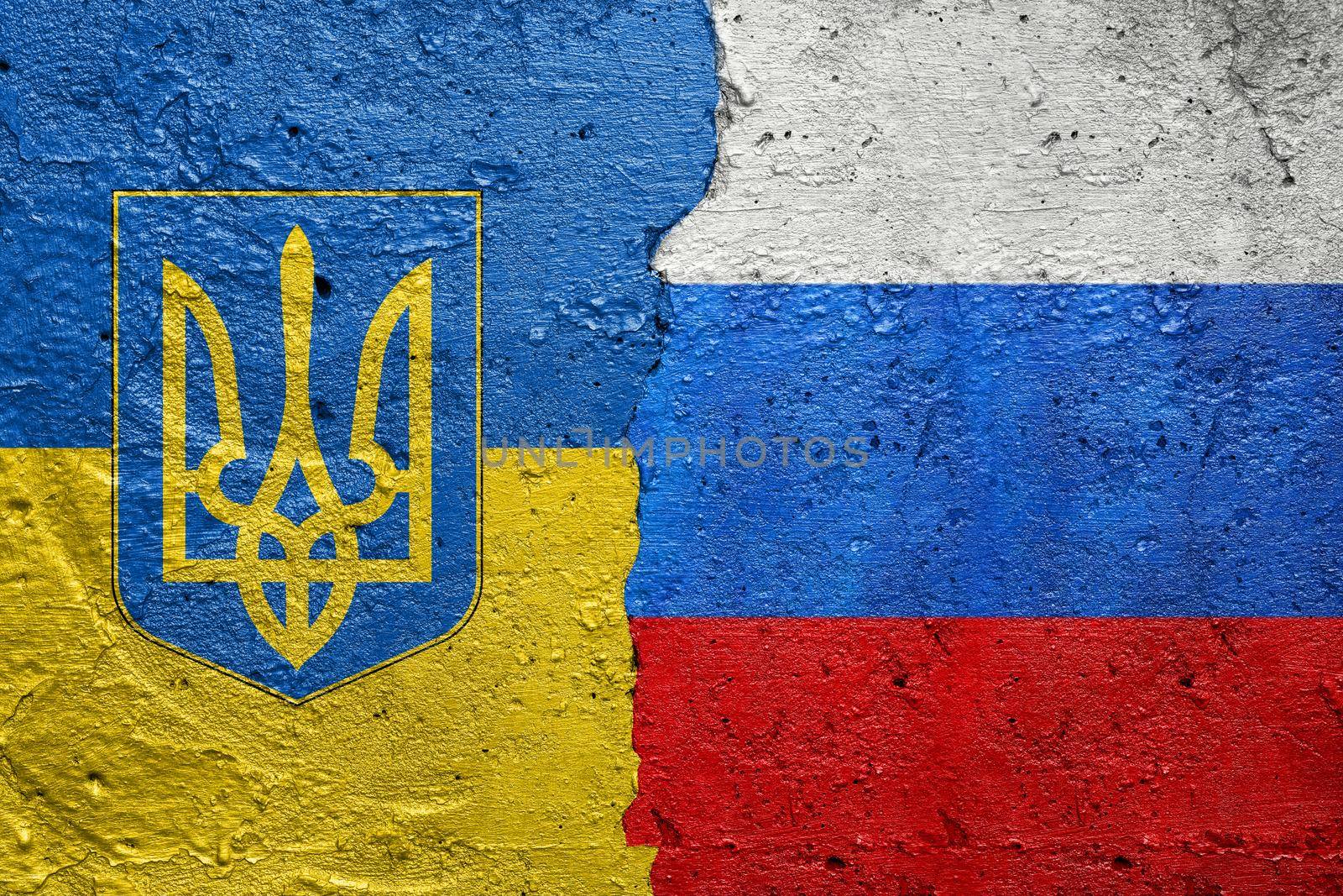 Ukraine and Russia flag- Cracked concrete wall painted with a Ukrainian flag on the left and a Russian flag on the right stock photo by adamr