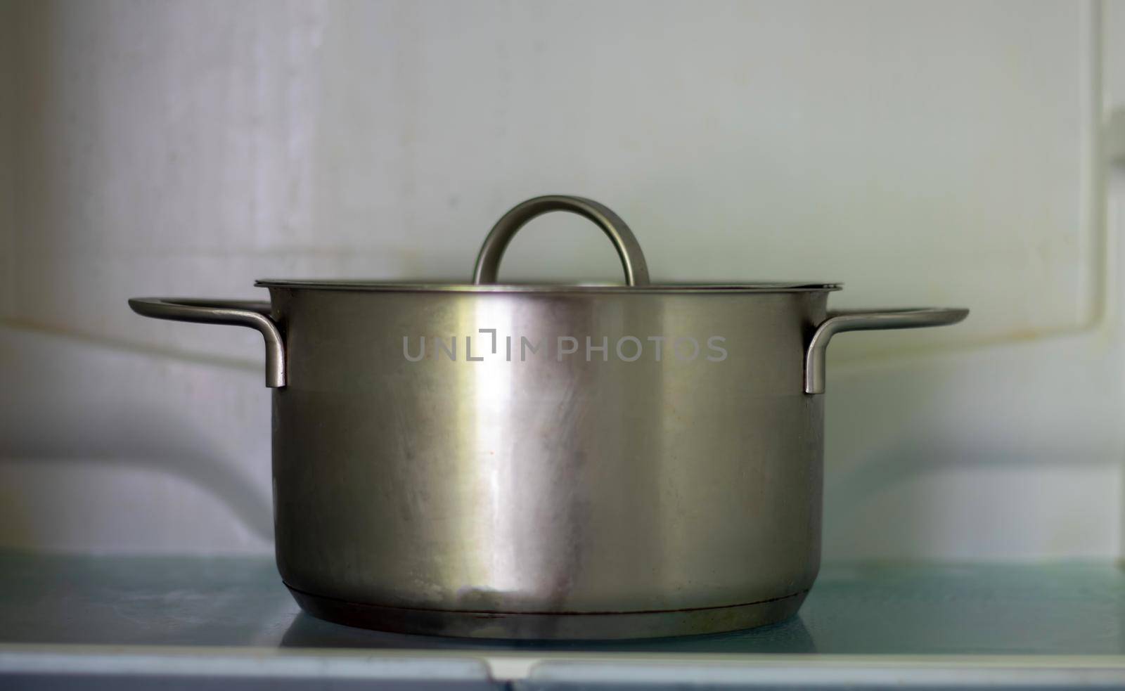 Freezer open pot close-up. Saucepan in an open refrigerator. The refrigerator inside is almost empty due to the economic crisis. Open refrigerator shelves with various cooked food