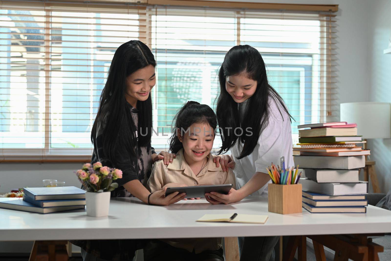 Three asian children doing their homework with digital tablet together.