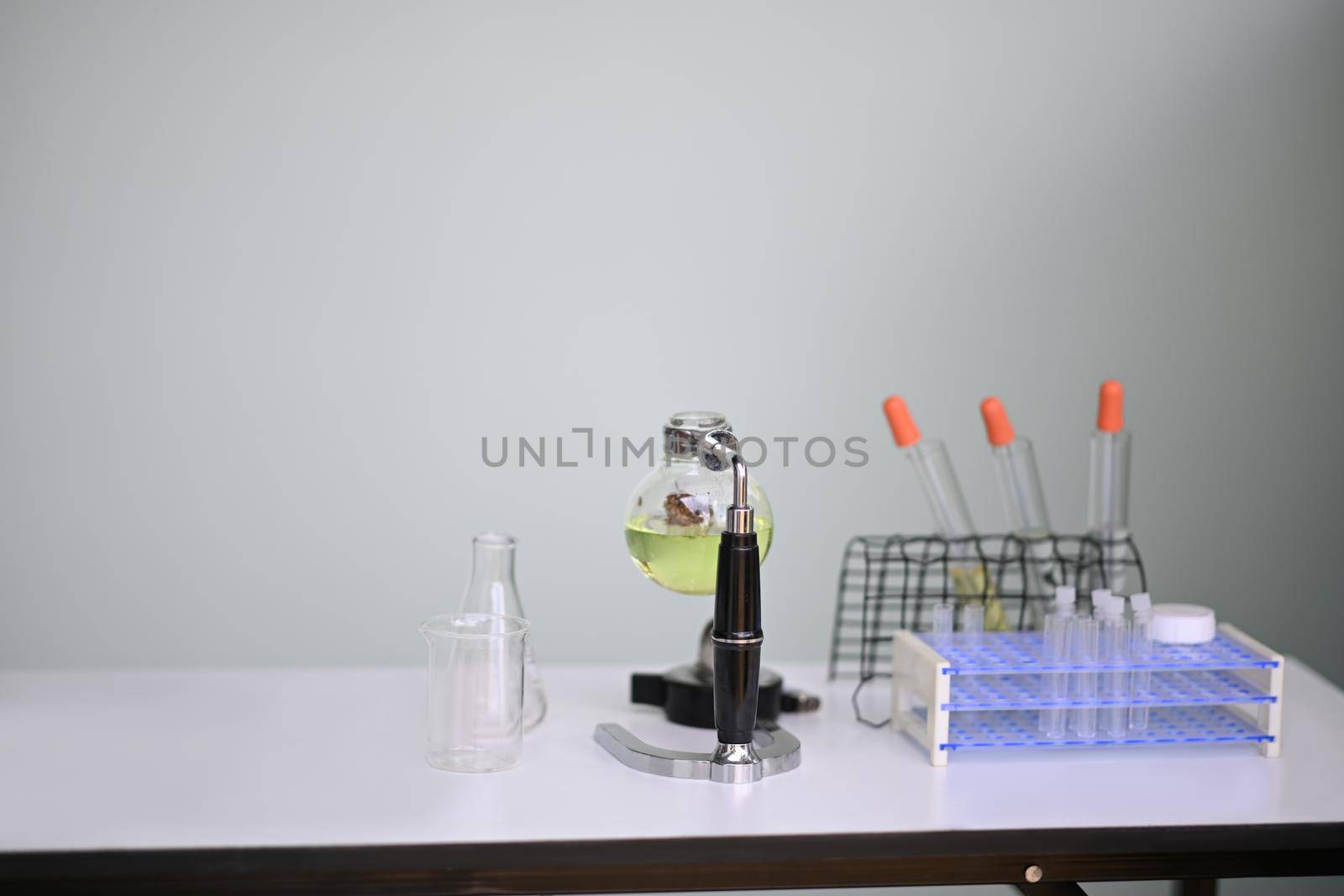 Glass bowl with cbd oil extracted from a marijuana plant on white table in laboratory. Herbal alternative medicine, cbd oil concept by prathanchorruangsak