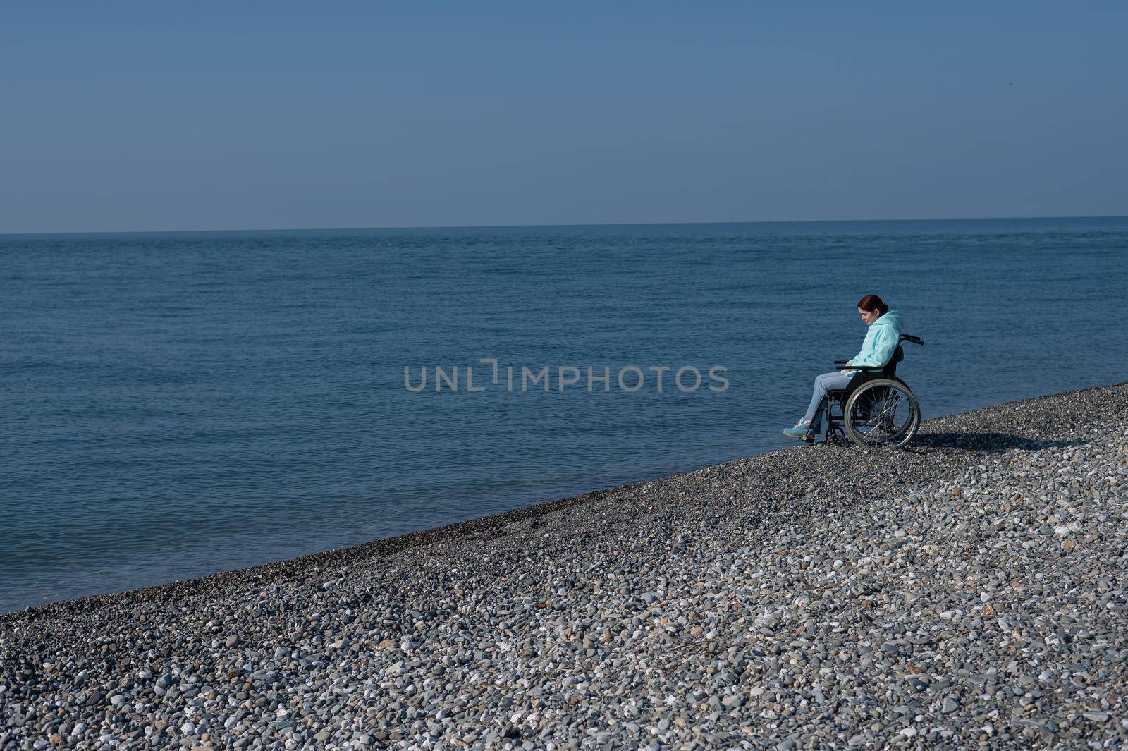 Pacified caucasian woman in a wheelchair on the seashore