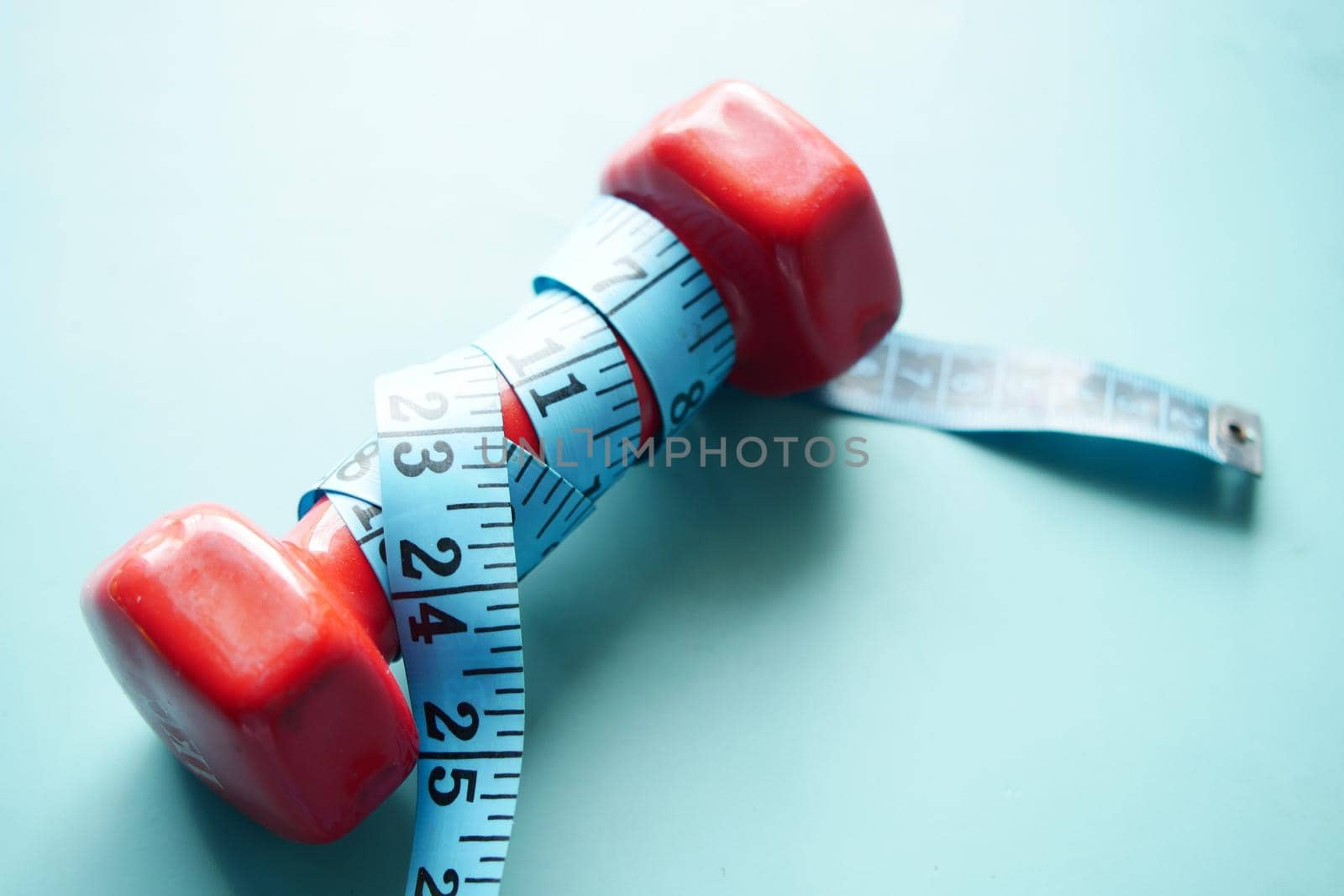 Fitness concept with dumbbell and measurement tape .