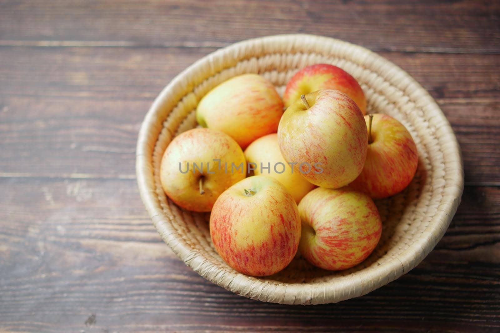 Close up of fresh apple in a bowl on wooden table.