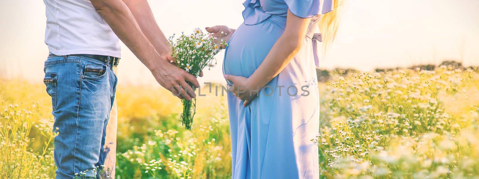 pregnant woman and man gives flowers. Selective focus. nature.