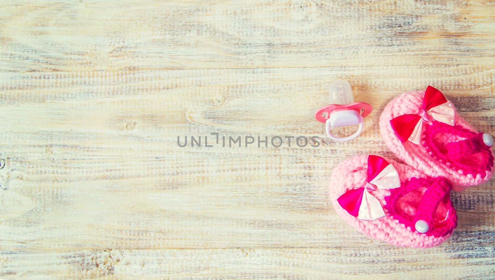 Baby booties and accessories on a light background. Selective focus.