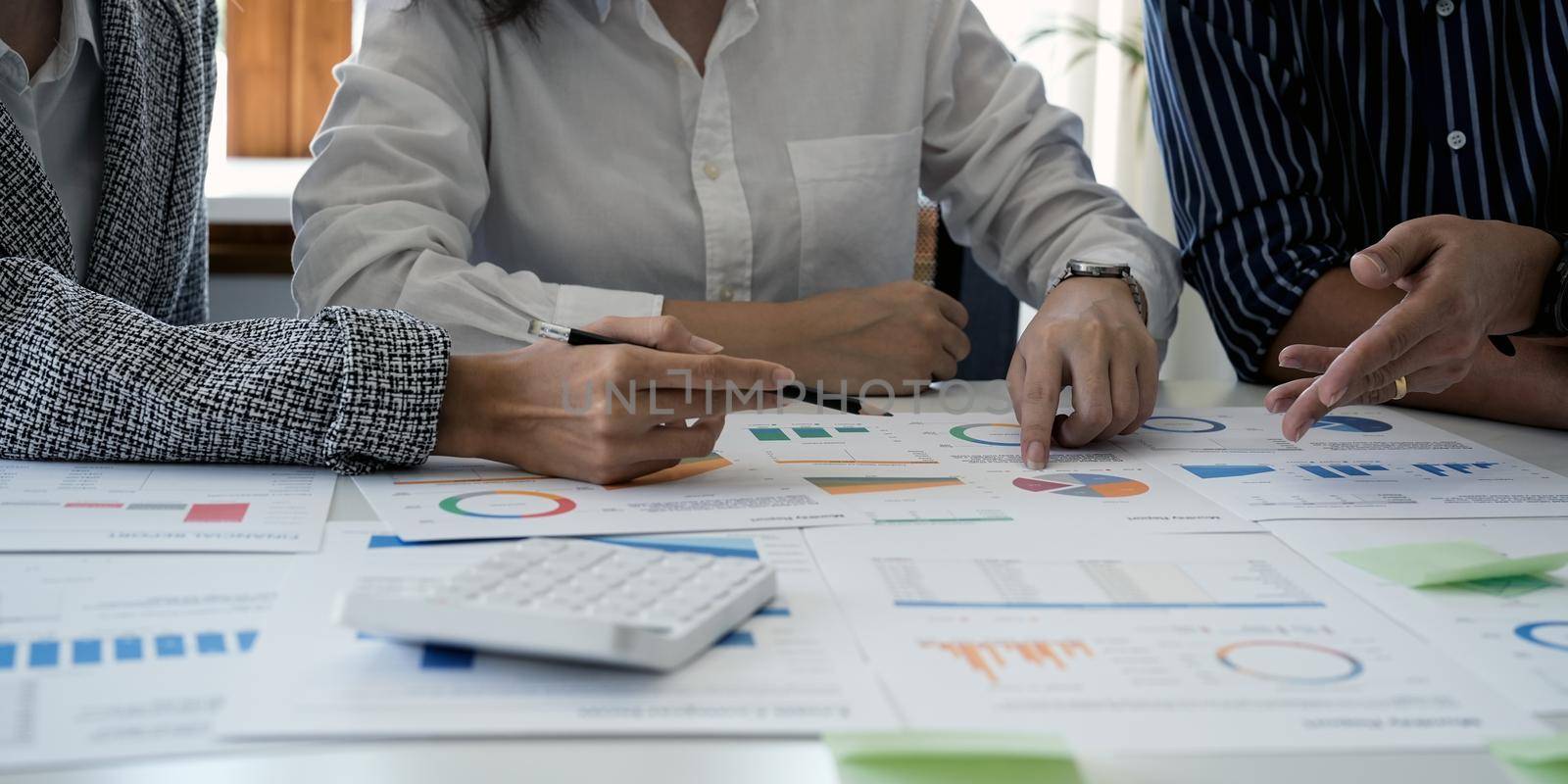 Close up hands using calculator of businessman and businesswoman discussing at meeting, focus at calculator